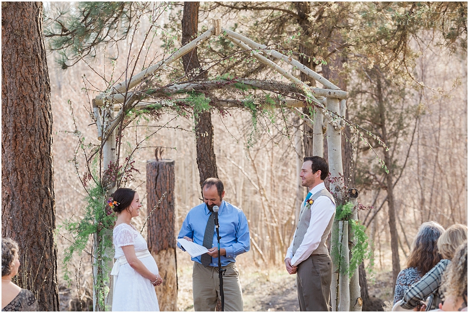 A couple stands under their aspen tree arbor ready to exchange vows at their rustic outdoor wedding in Central Oregon. 