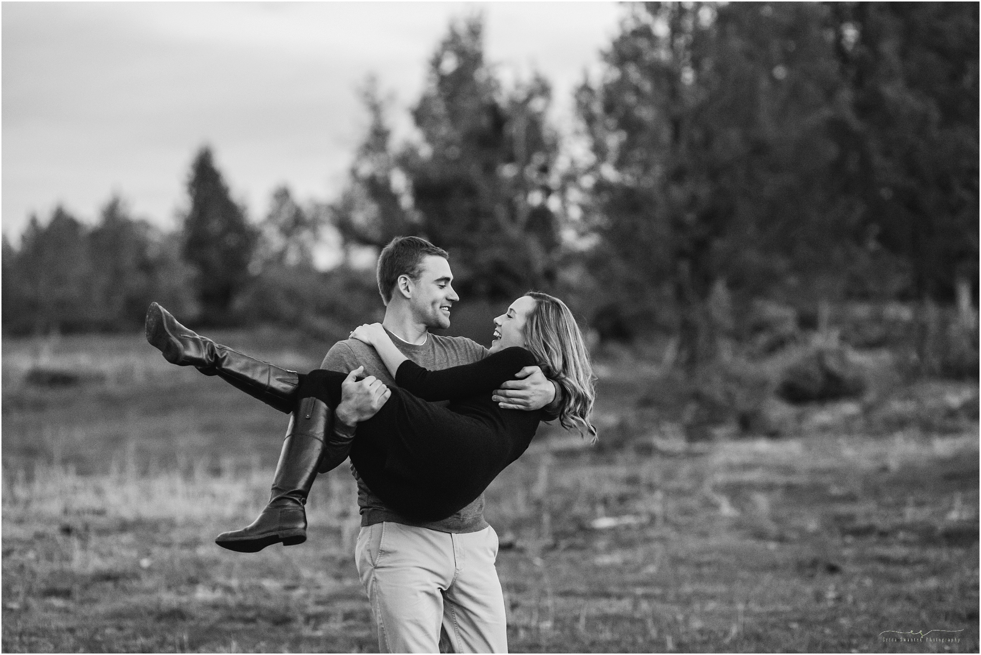 A man holds a woman in his arms outside their beautiful Powell Butte, Oregon property in this classic black and white image. | Erica Swantek Photography