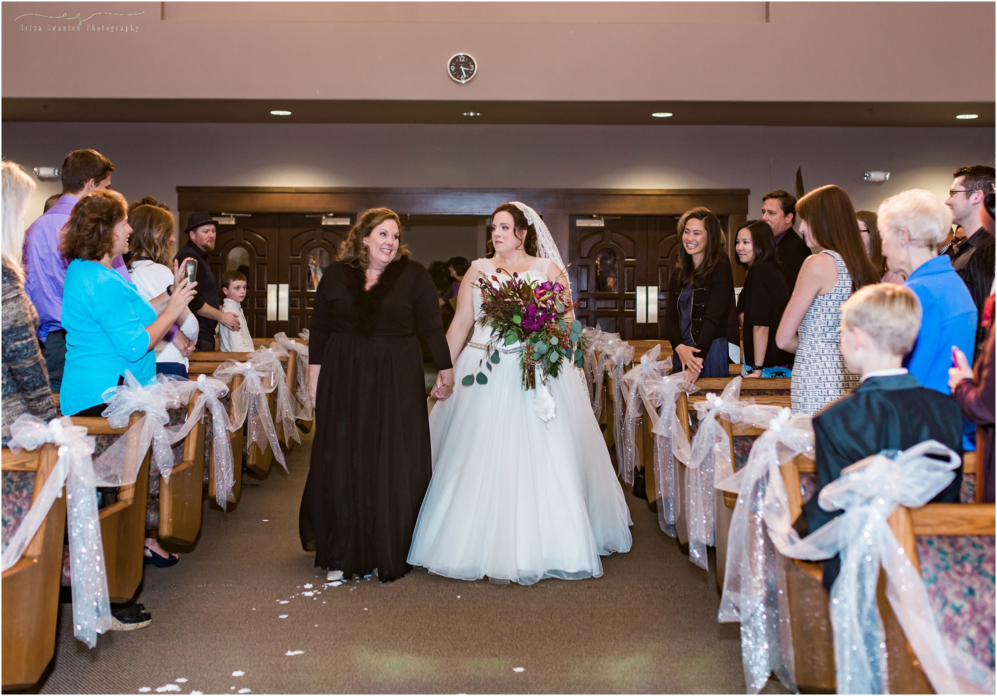 A mother walks her daughter down the aisle to meet her groom. at this Bend, Oregon winter woodland wedding. 