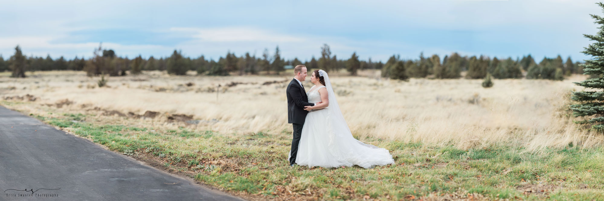 a couple stands in a field with the Cascade Mountains behind them at this Bend, Oregon winter wedding. | Erica Swantek Photography
