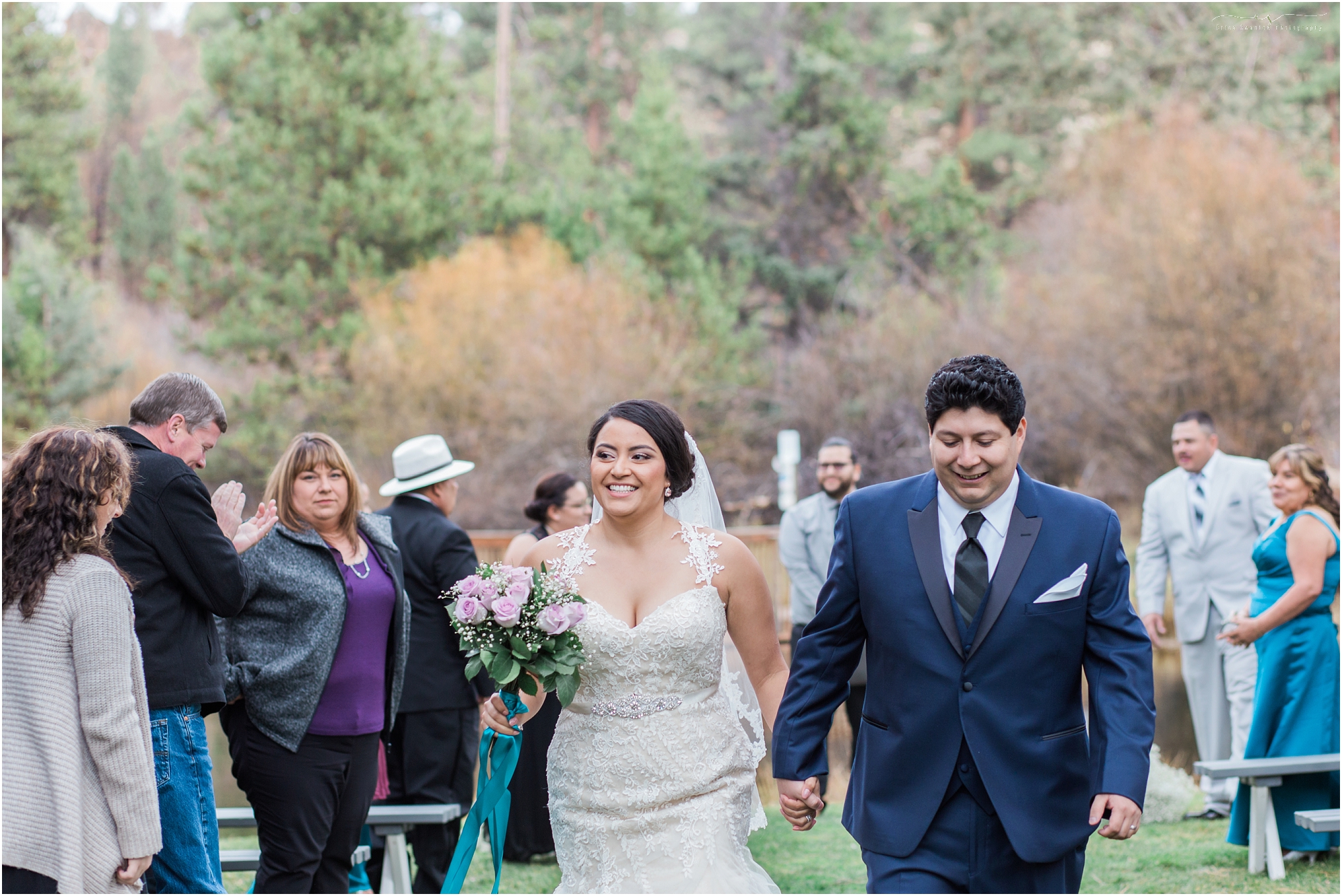A newly pronounced husband & wife walk back down the aisle towards their reception at Aspen Hall in Bend, OR. 