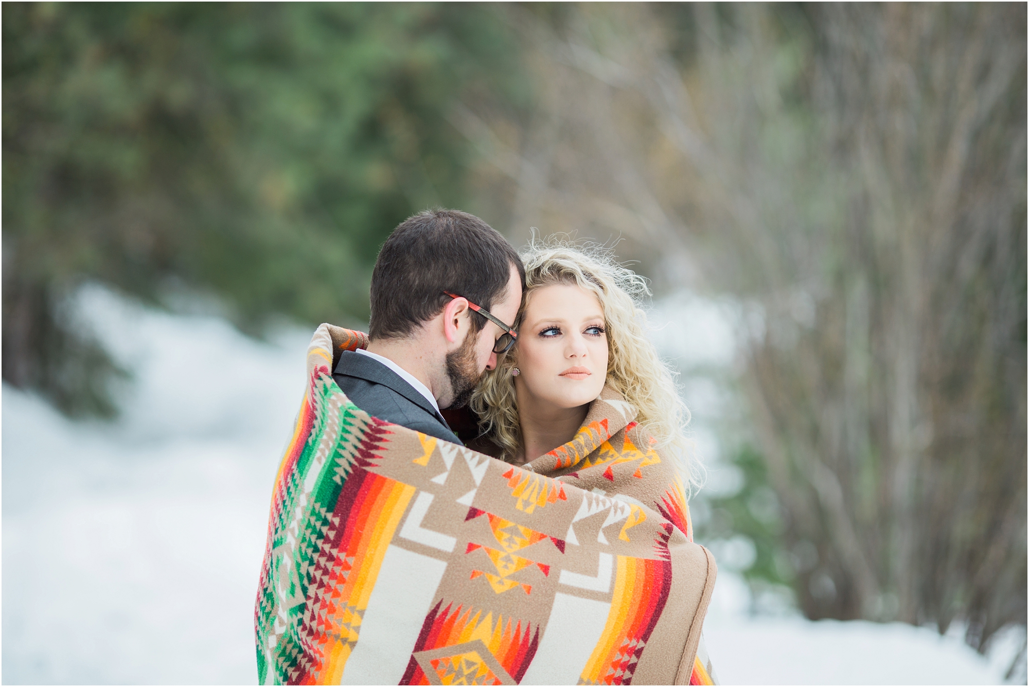 A wedding couple wrapped in a Pendleton wool blanket outside in the snow in Leavenworth, WA. | Erica Swantek Photography