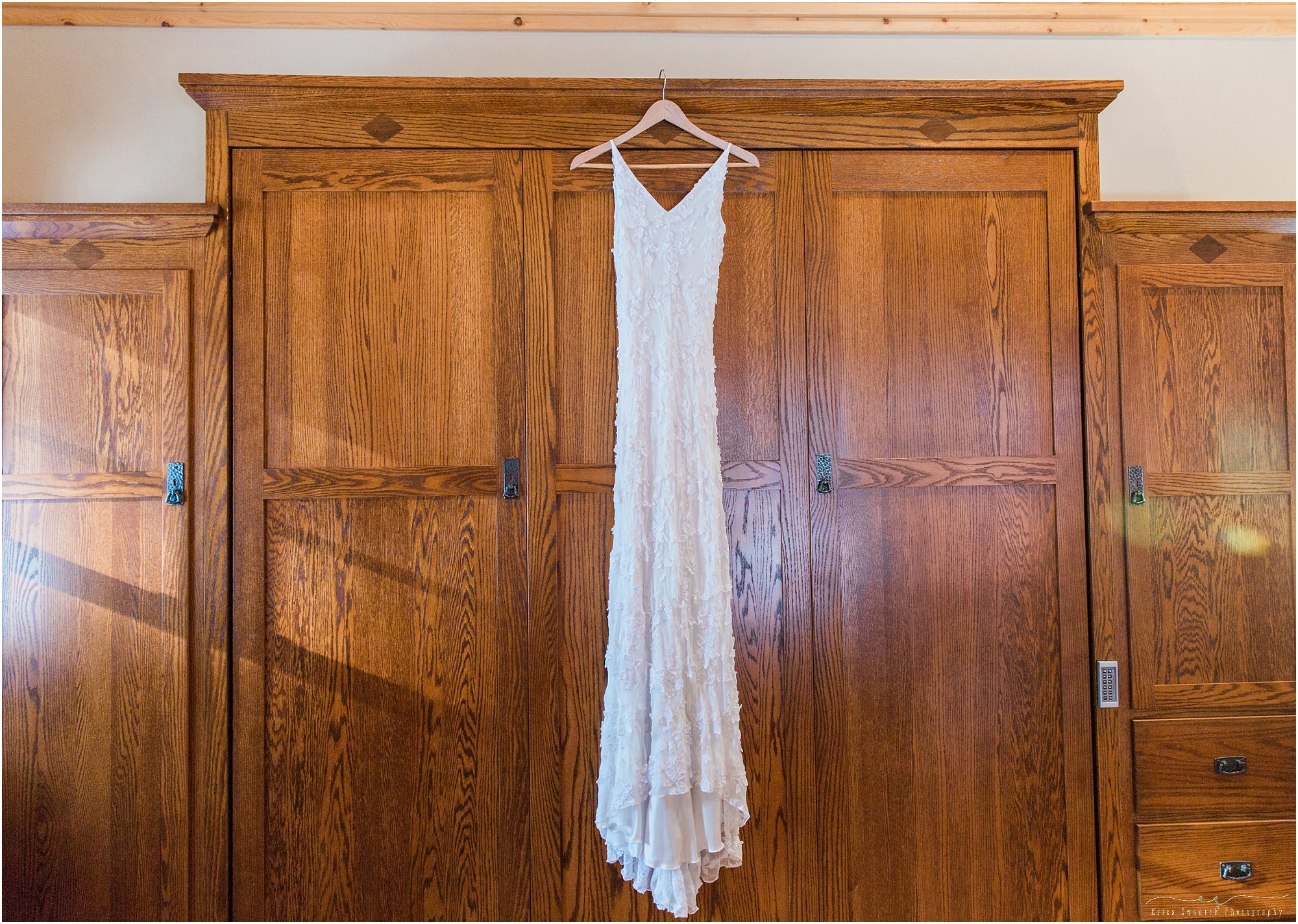 A gorgeous handmade gown hanging on the wardrobe of this Fine Pine Lodge bridal cabin at this Sisters Oregon winter wedding. 