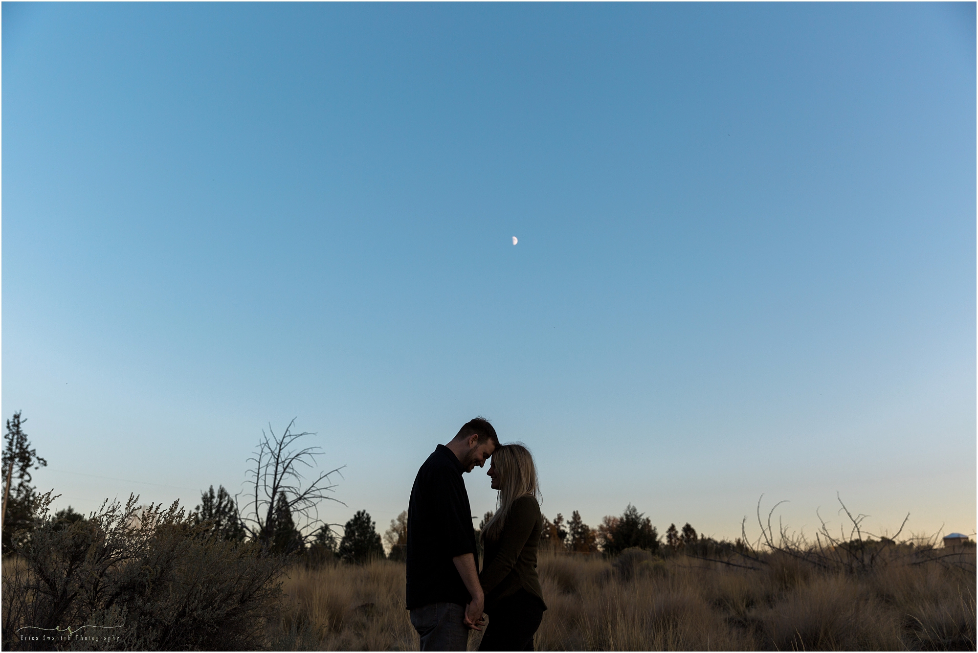 The moon rises behind the silhouette of a couple during their engagement photos at Smith Rock State Park in Oregon. | Erica Swantek Photography