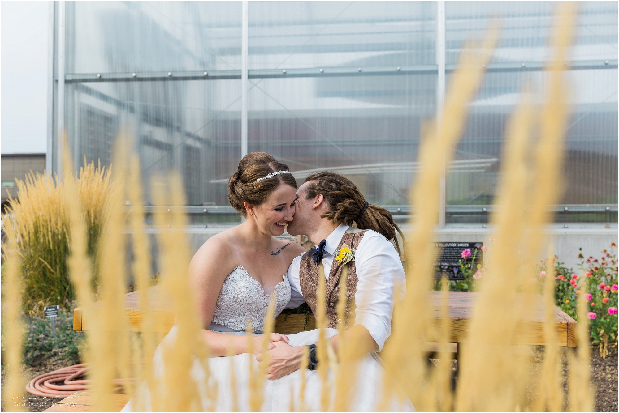 A couple sits on the bench in front of the greenhouse in the gorgeous gardens of their Worthy Brewing Wedding in Bend Oregon. | Erica Swantek Photography