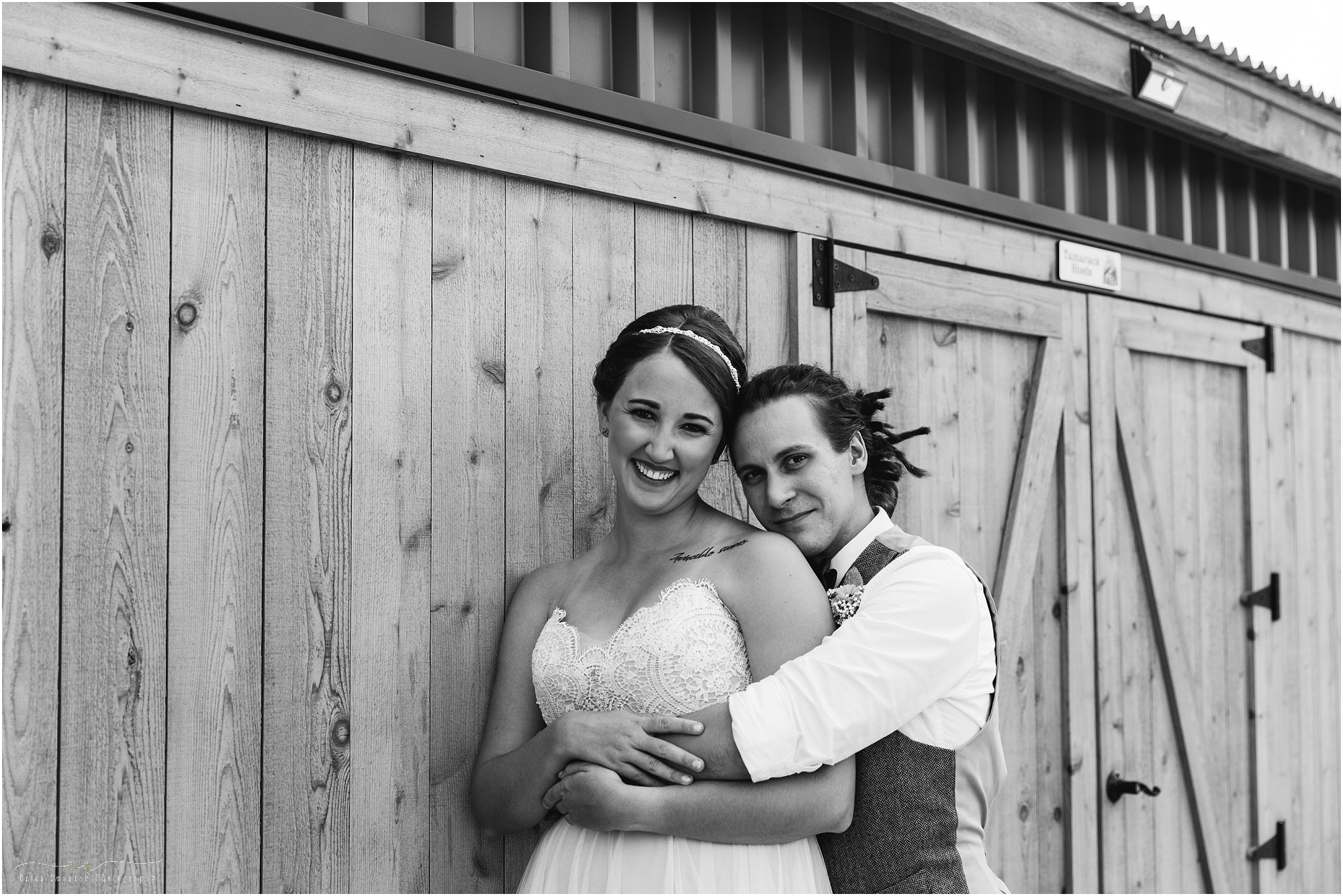 A gorgeous black and white photo of the bride and groom in front of a barn door at their Worthy Brewing Wedding. Photographed by Bend Oregon wedding photographer Erica Swantek Photography. 