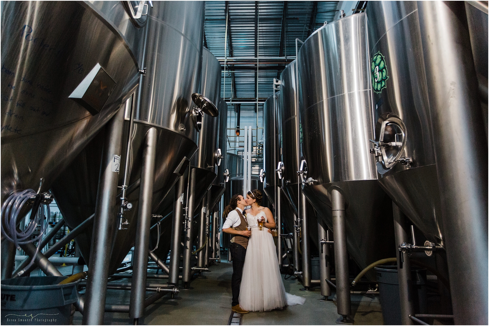 The stainless steel brewing fermenters create a cool portrait of the couple at their Worthy Brewing Wedding in Bend Oregon. | Erica Swantek
