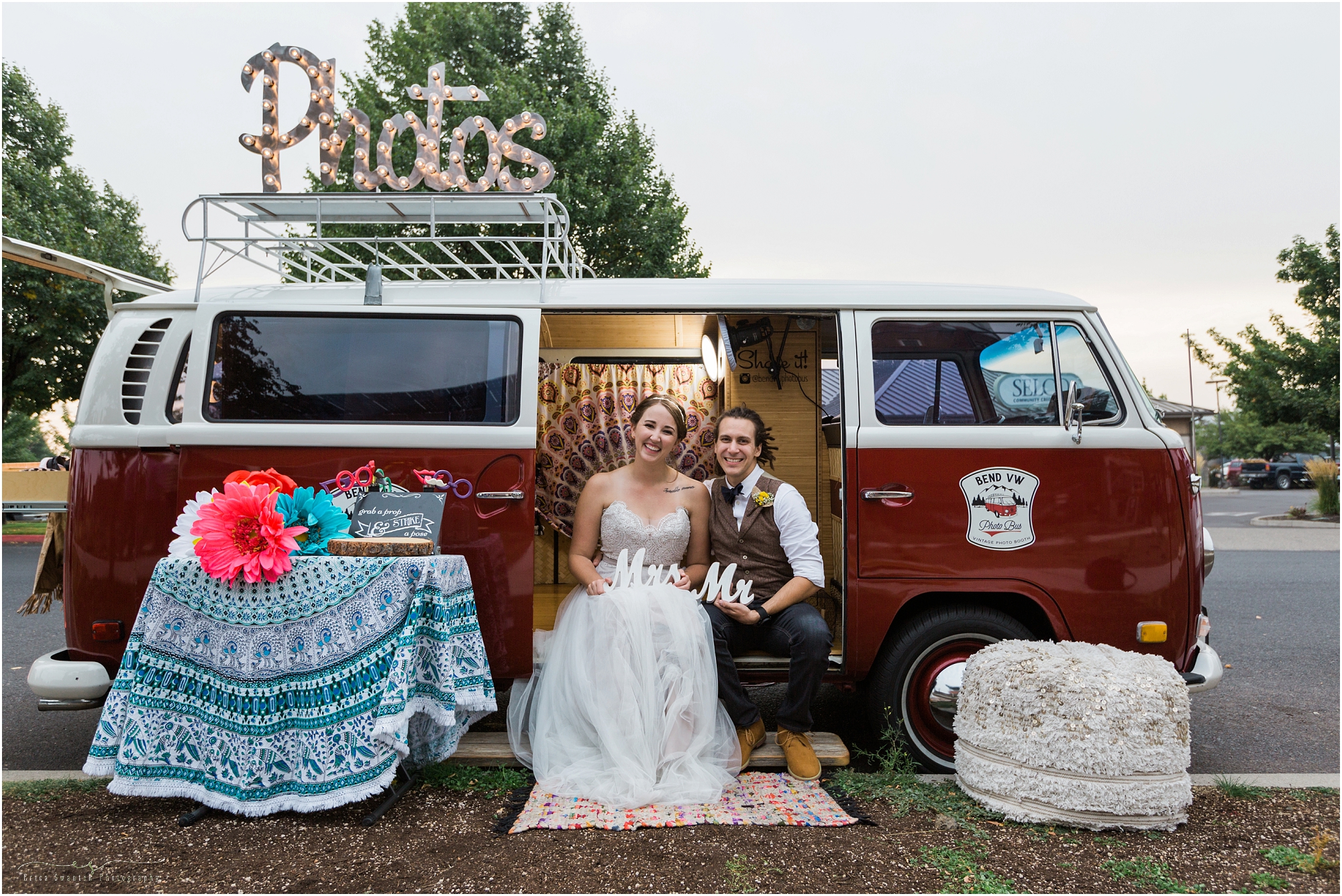 The wedding couple poses with the red VW photo bus booth parked at their Worthy Brewing Wedding in Bend Oregon. | Erica Swantek Photography