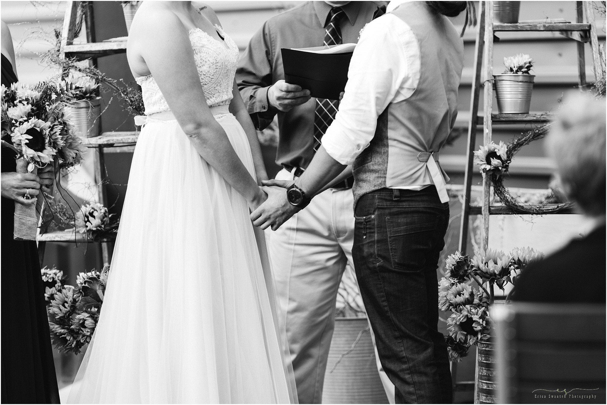 A beautiful black and white photograph of a couple's hands as they say their vows during their ceremony of their Worthy Brewing Wedding. | Erica Swantek Photography