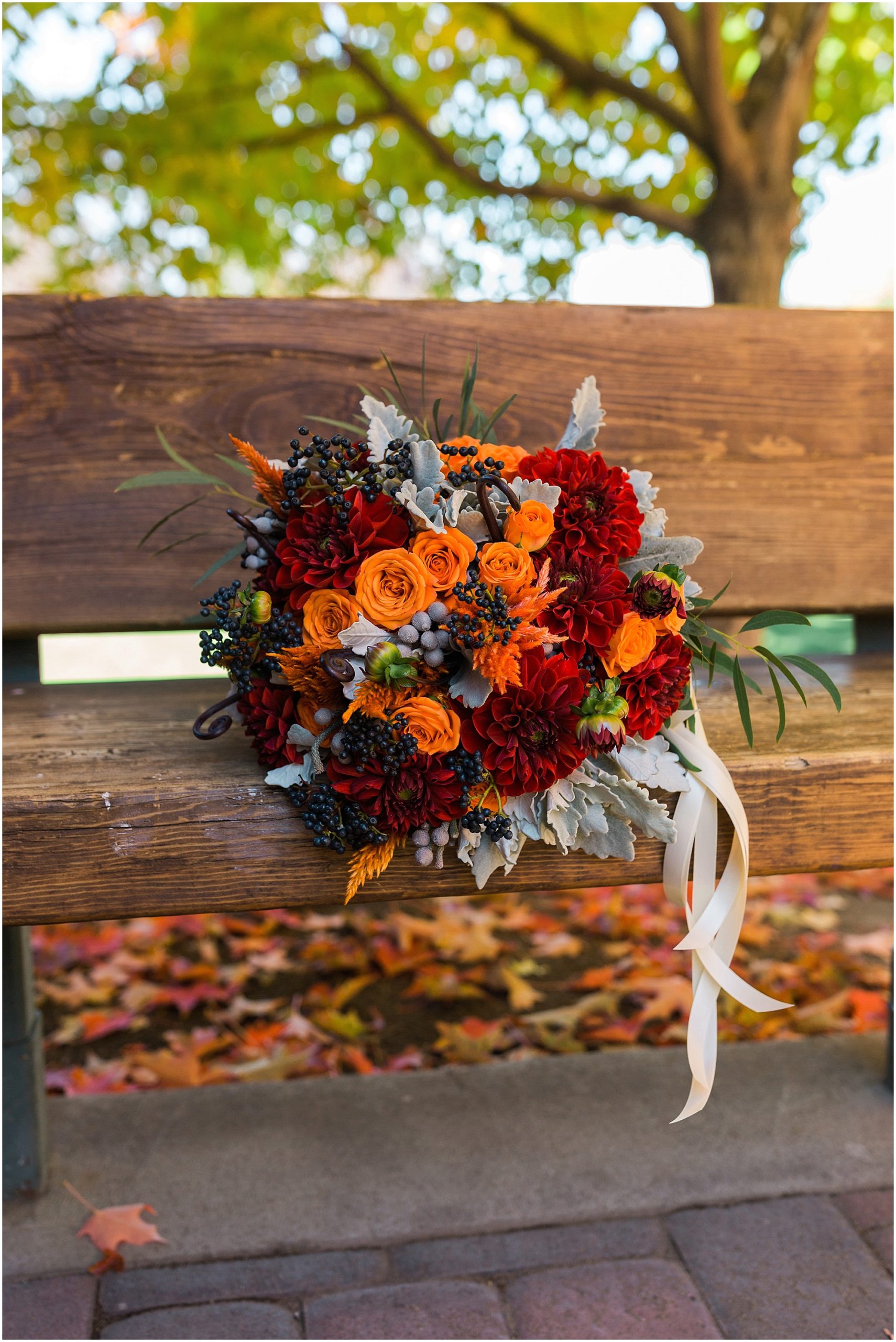 A stunning bouquet in beautiful reds, oranges and deep greens are perfect for a Hollinshead Barn Fall Wedding in Bend, Oregon. | Erica Swantek Photography
