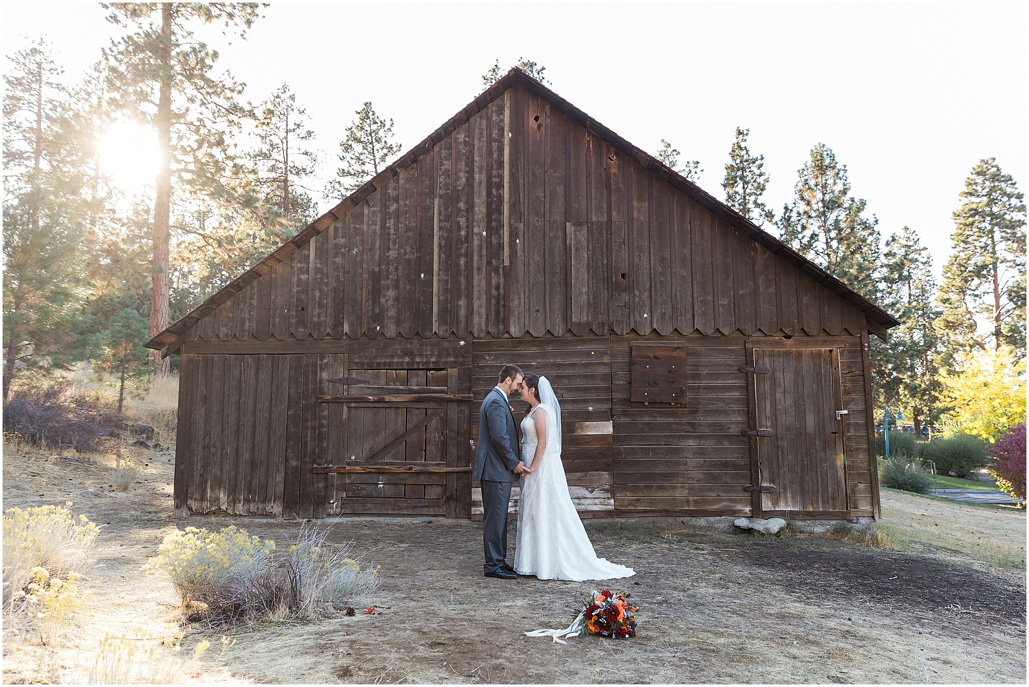Newlyweds pose in front of the rustic barn at their wedding in Bend, Oregon's Hollinshead Park for their Hollinshead Barn fall wedding. | Erica Swantek Swantek