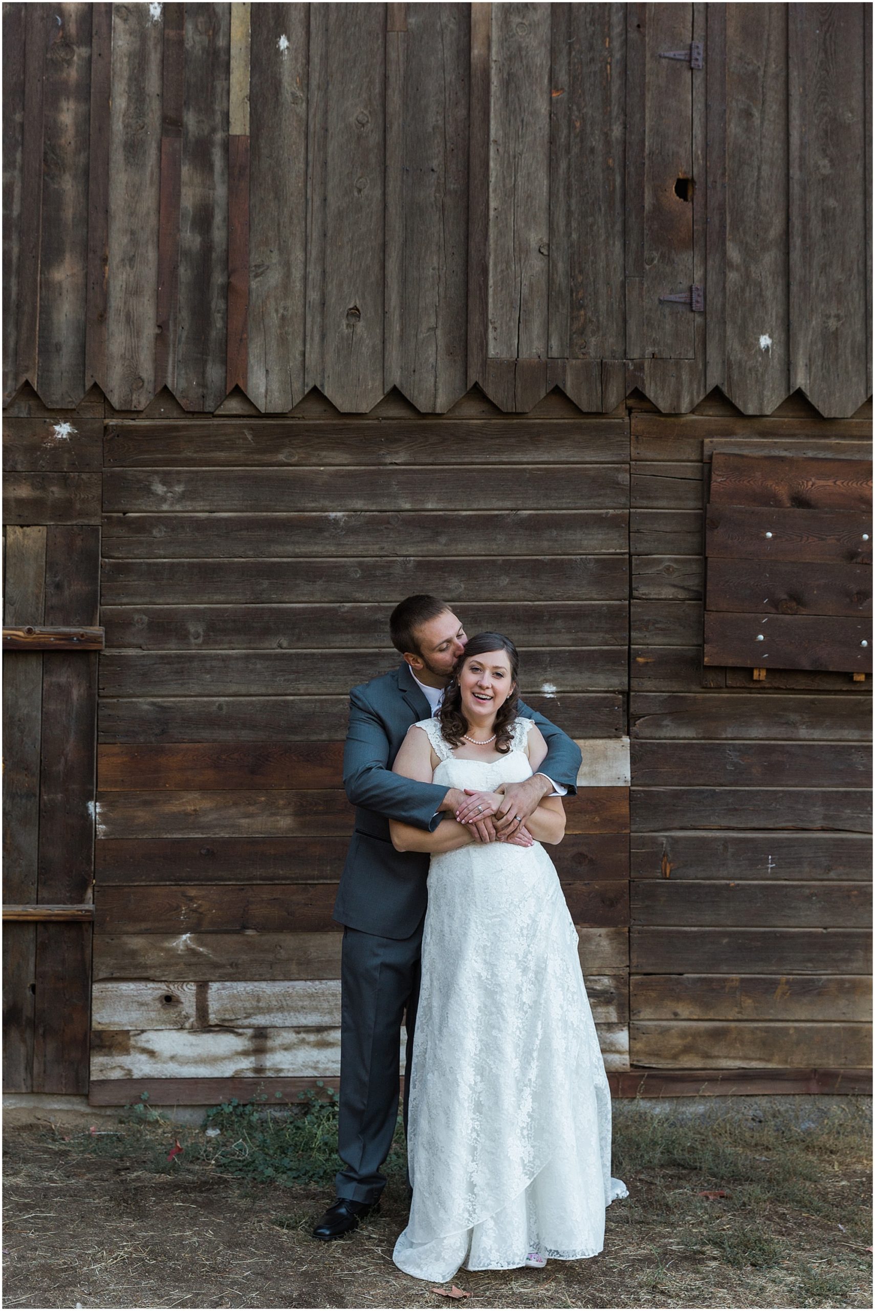 Newlyweds pose in front of the rustic barn at their wedding in Bend, Oregon's Hollinshead Park for their Hollinshead Barn fall wedding. | Erica Swantek Swantek