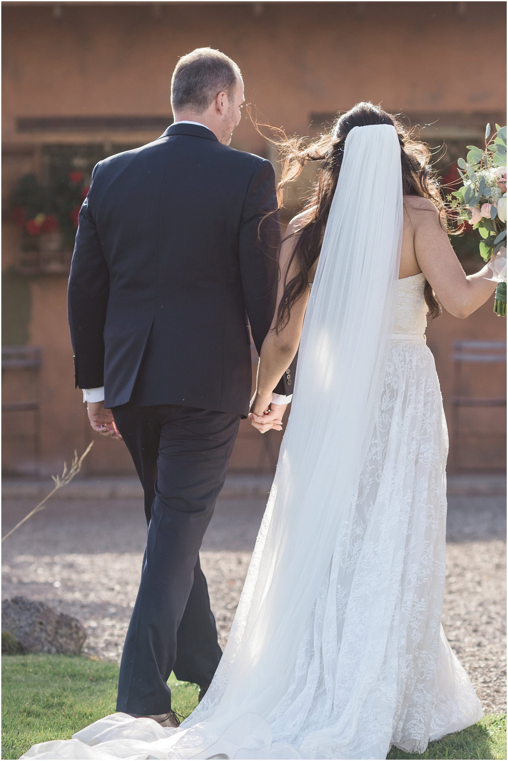 A couple walks hand in hand after tying the knot at the Tuscan Stables at their Ranch at the Canyons fall wedding in Central Oregon. | Erica Swantek Photography