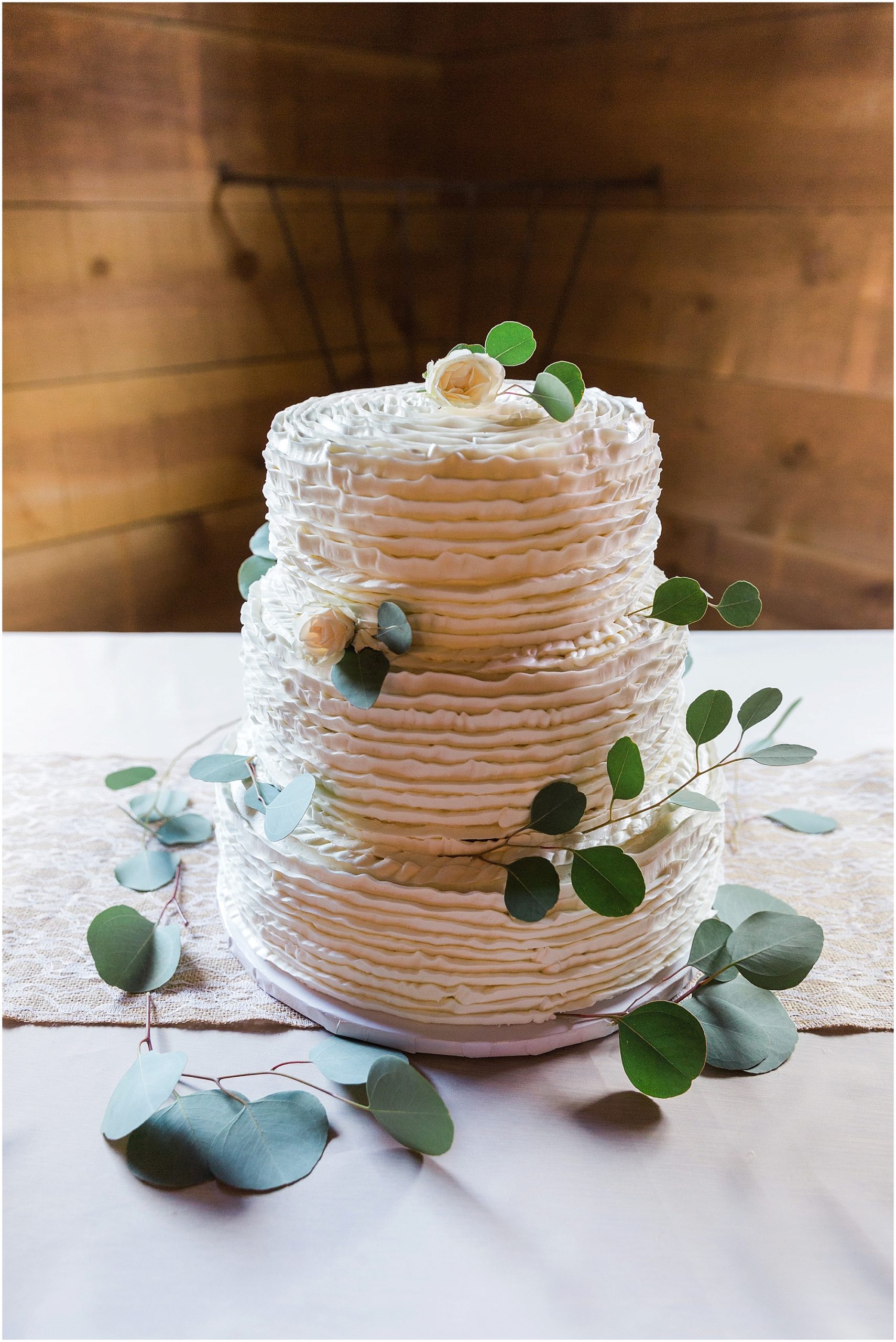A luscious three tiered wedding cake with eucalyptus greenery for guests at a Ranch at the Canyons fall wedding in Oregon. | Erica Swantek Photography