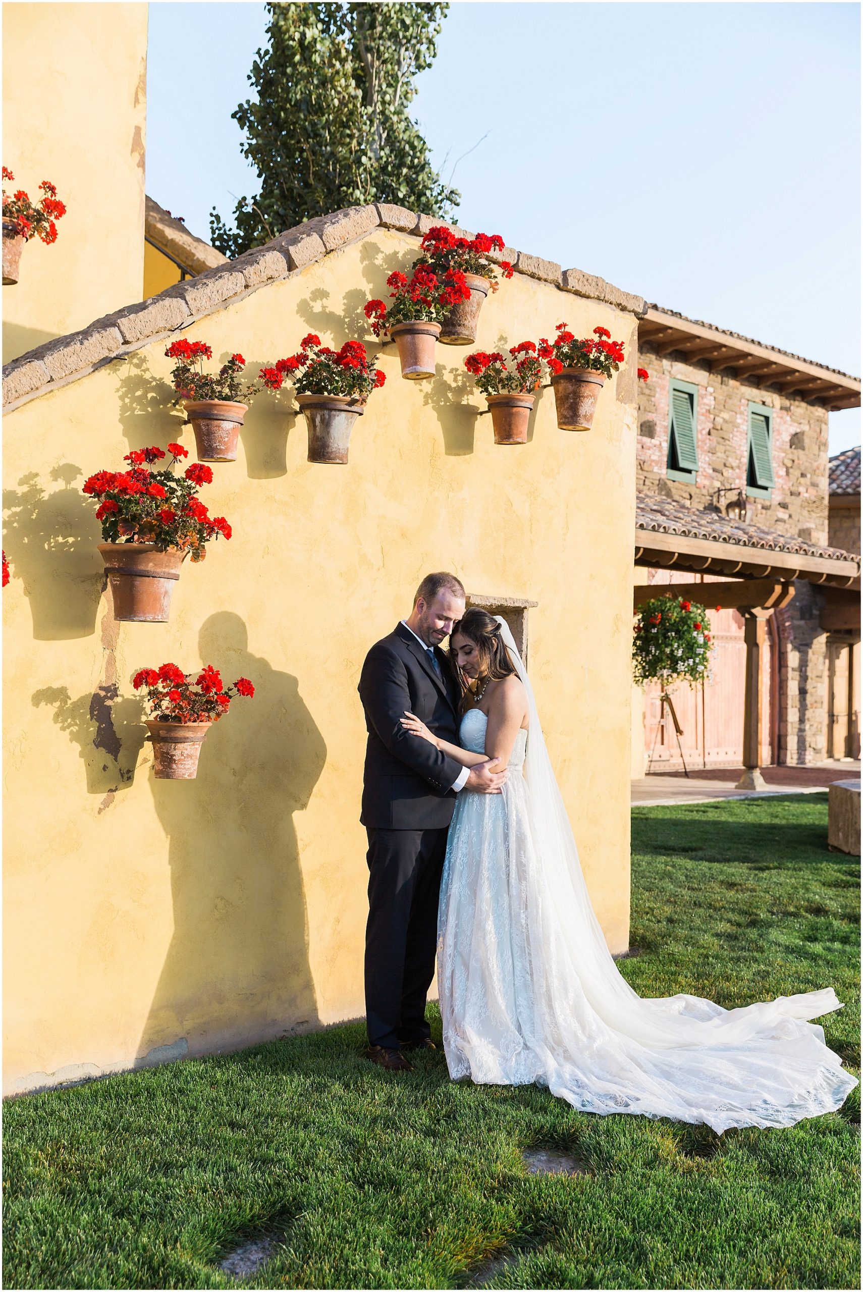 The baskets adorned with red flowers hanging from the yellow walls are such a pretty pop of color for this wedding couple's portraits at their Ranch at the Canyons fall wedding. Photographed by Bend Oregon wedding photographer Erica Swantek Photography. 