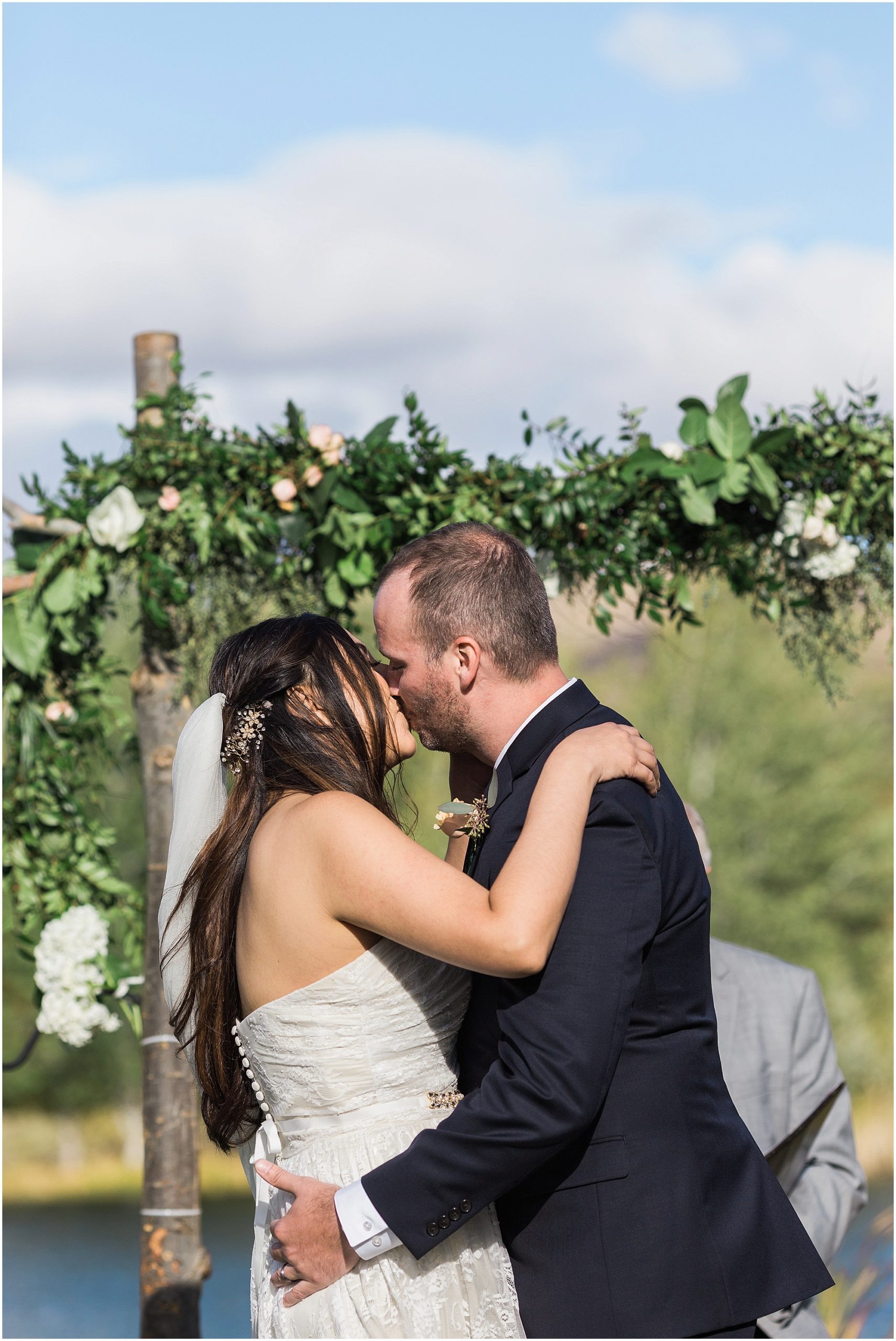 The couple's first kiss during the outdoor ceremony at the Tuscan Stables wedding venue at Ranch at the Canyons in Central Oregon. | Erica Swantek Photography