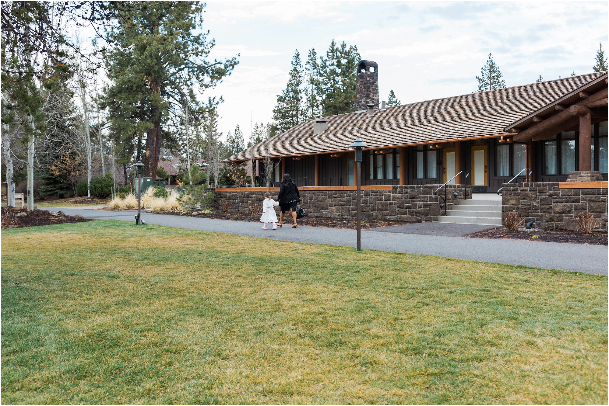 This bride's aunt walks her young daughter back to their hotel room while her parents head out for their romantic couple's portraits at their Sunriver Resort wedding near Bend, OR. | Erica Swantek Photography