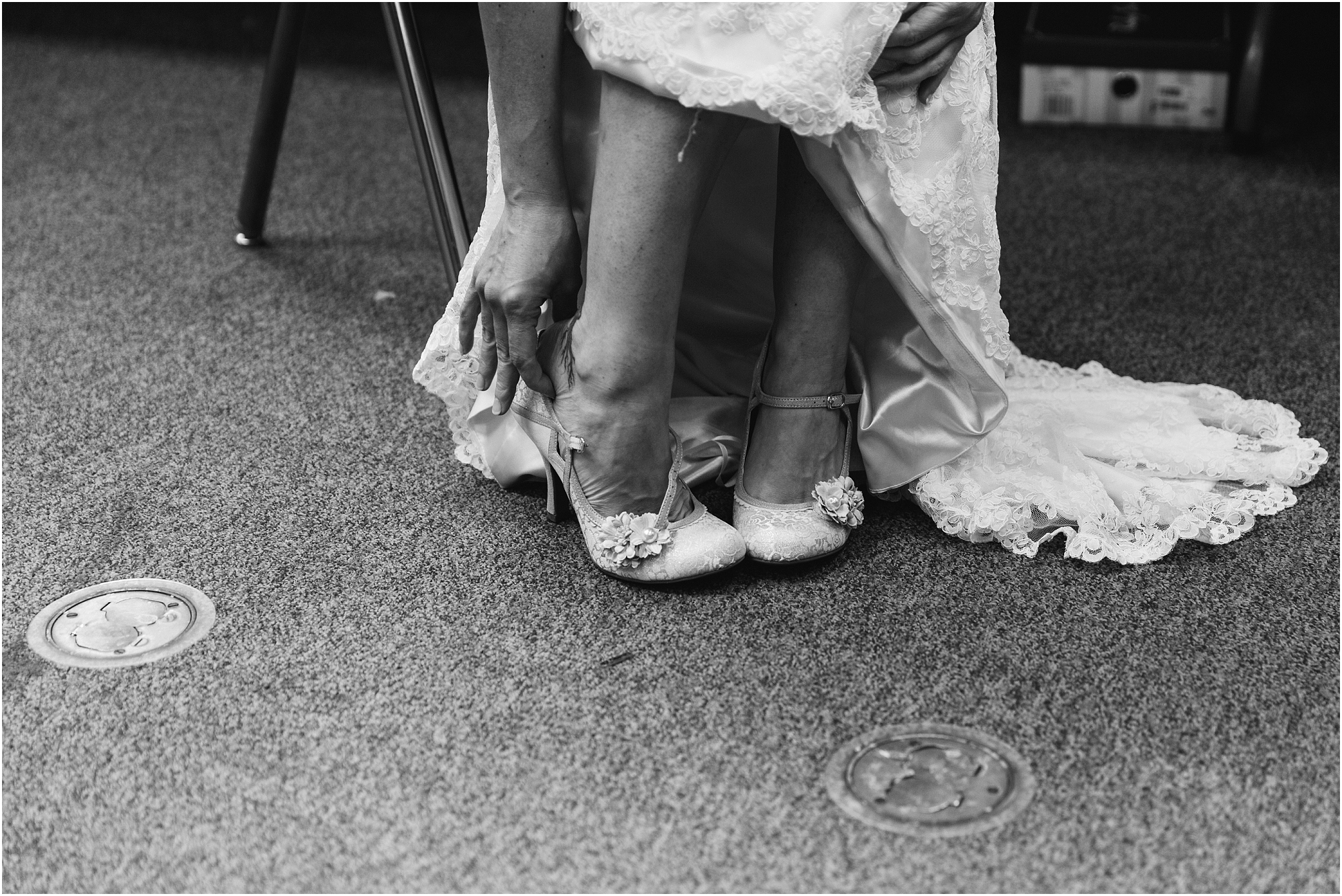 The bride slips on her beautiful ivory shoes in her getting ready room at the High Desert Museum in Bend, OR. | Erica Swantek Photography
