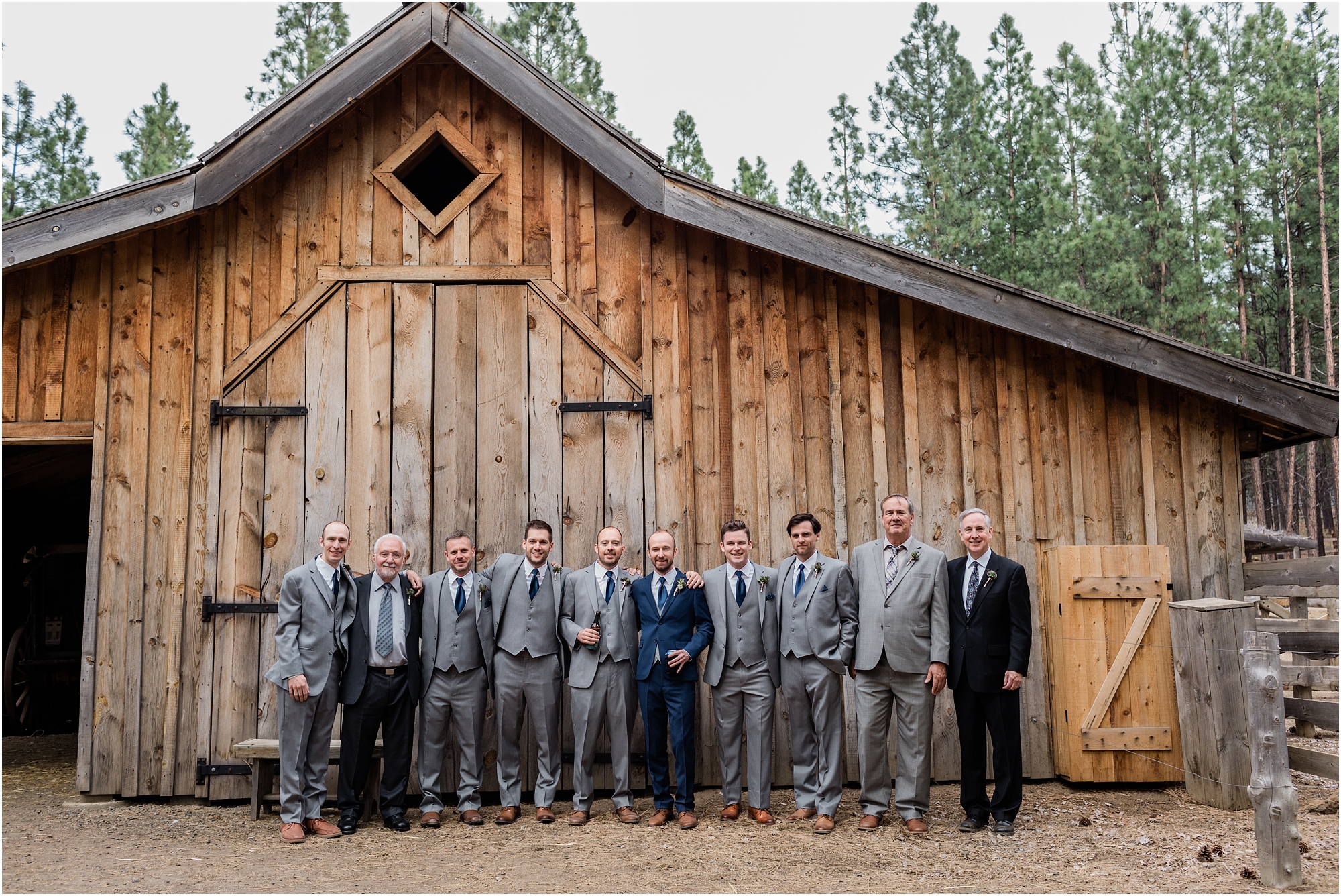 All the guys in the wedding party and family pose outside the horse stable at this High Desert Museum homestead wedding in Bend, OR. | Erica Swantek Photography