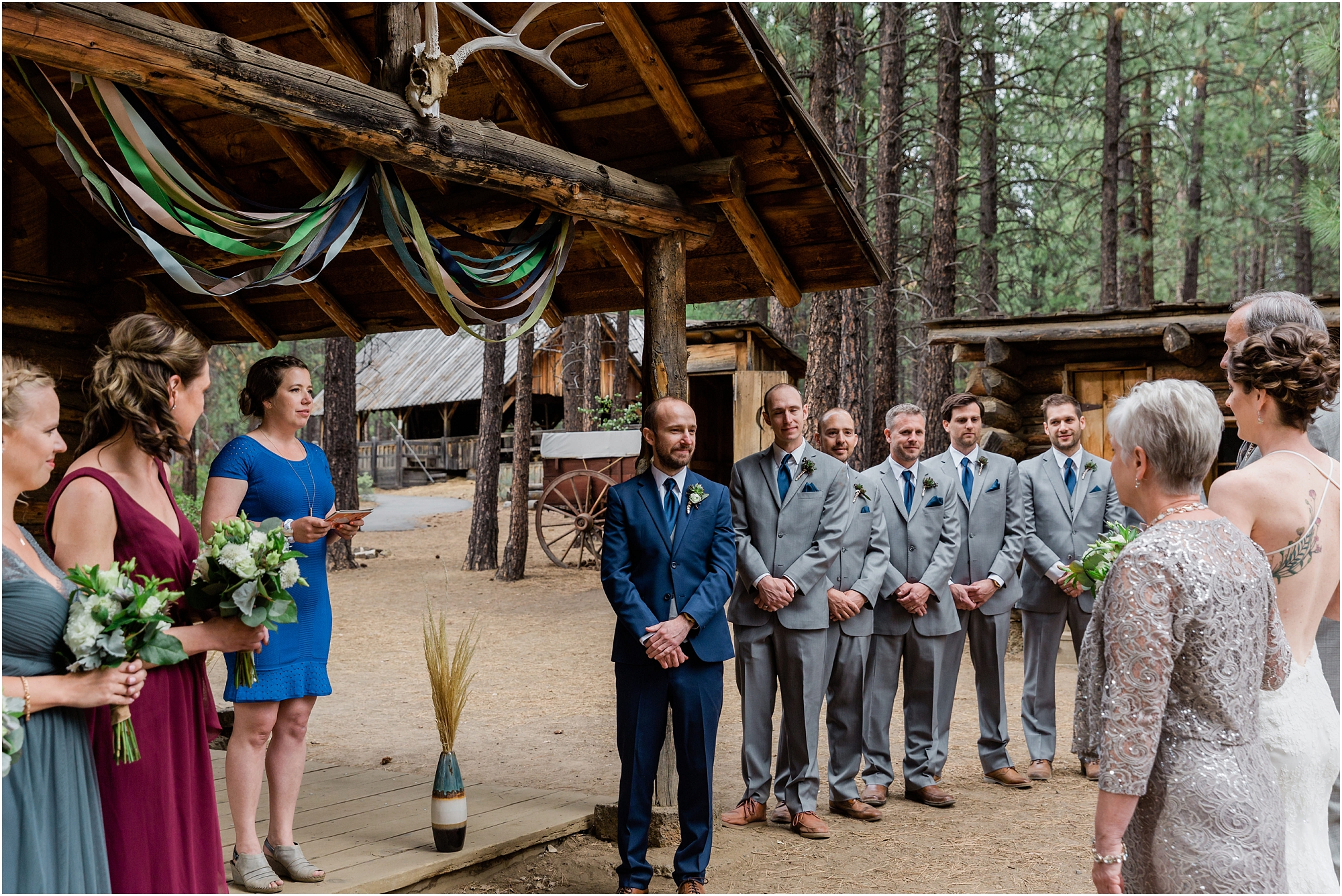 The groom waits as his bride is handed off by her parents in front of their friends at family at their Bend, Oregon wedding in the spring. | Erica Swantek Photography