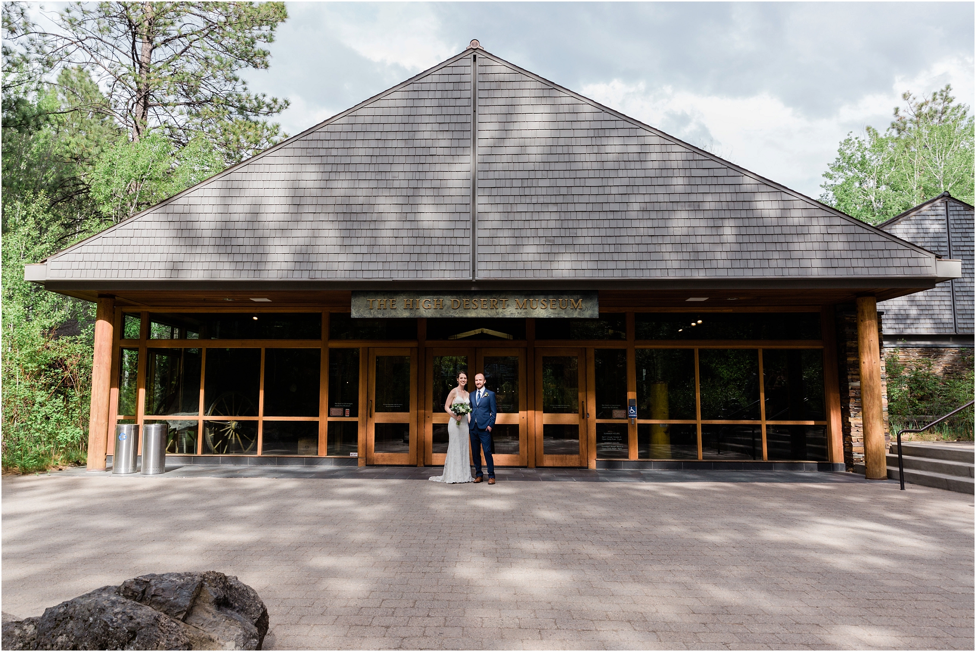 A bride and groom pose in front of the entrance to the gorgeous High Desert Museum is a lovely wedding venue in Bend, OR. | Erica Swantek Photography