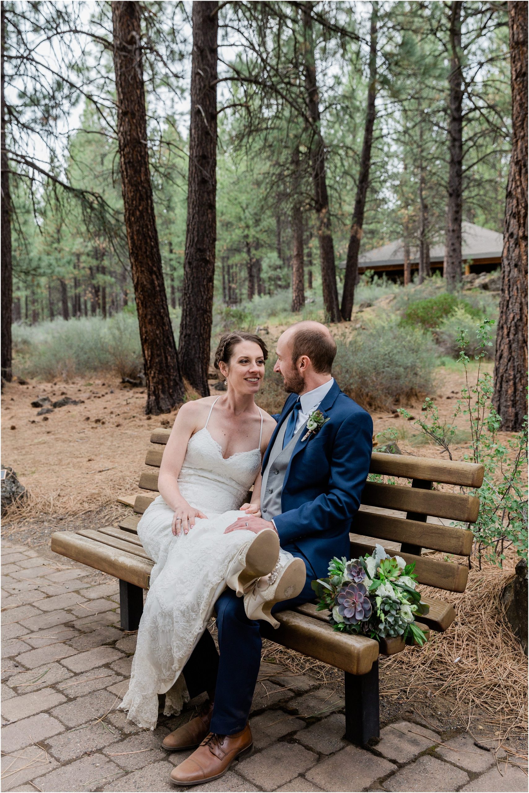 A bride relaxes with her feet on her groom's lap as they pose for their wedding portraits at this Oregon museum wedding venue. | Erica Swantek Photography