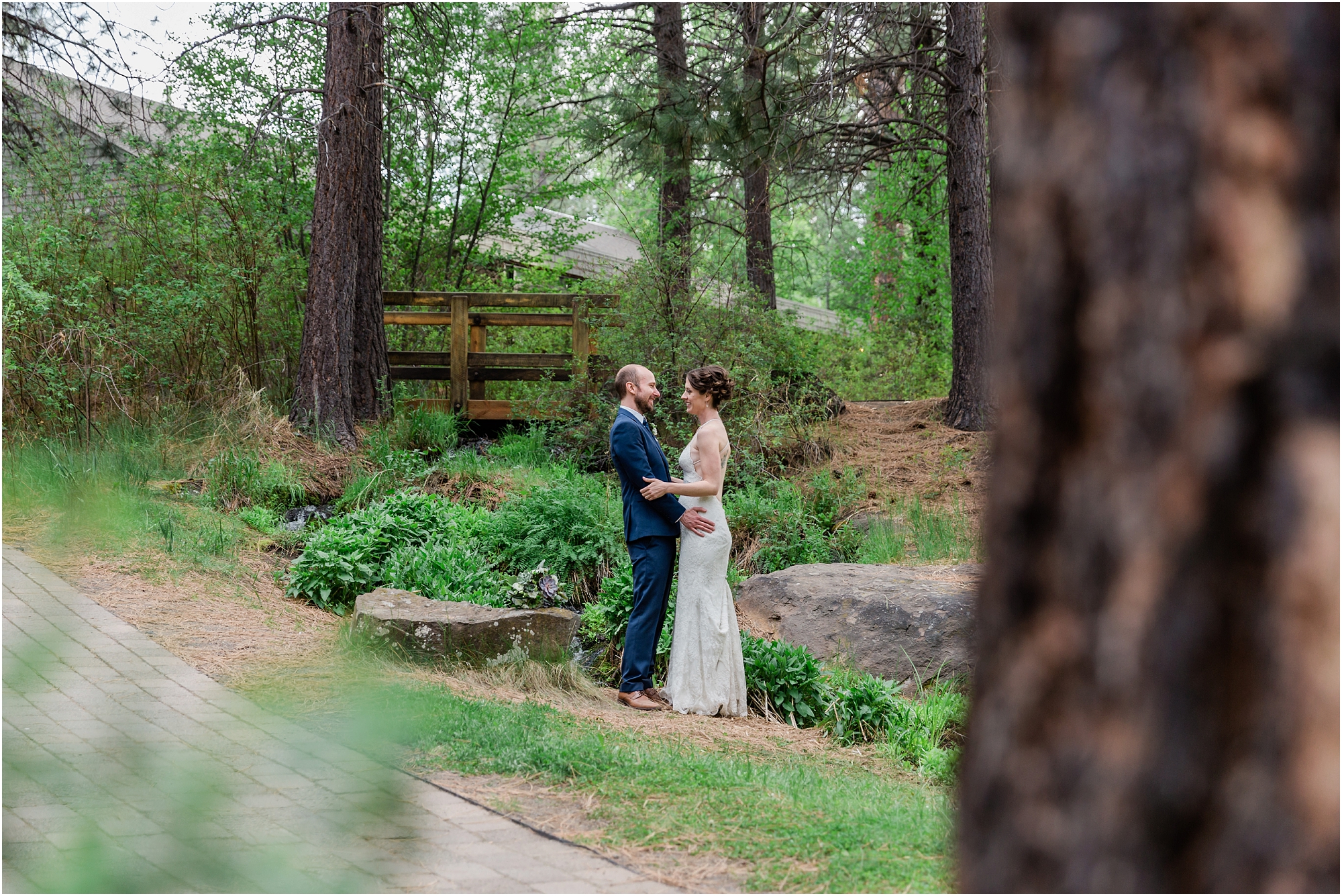 A newly married couple poses together amongst the pines and water feature at the gorgeous High Desert Museum wedding venue in Bend, OR. | Erica Swantek Photography