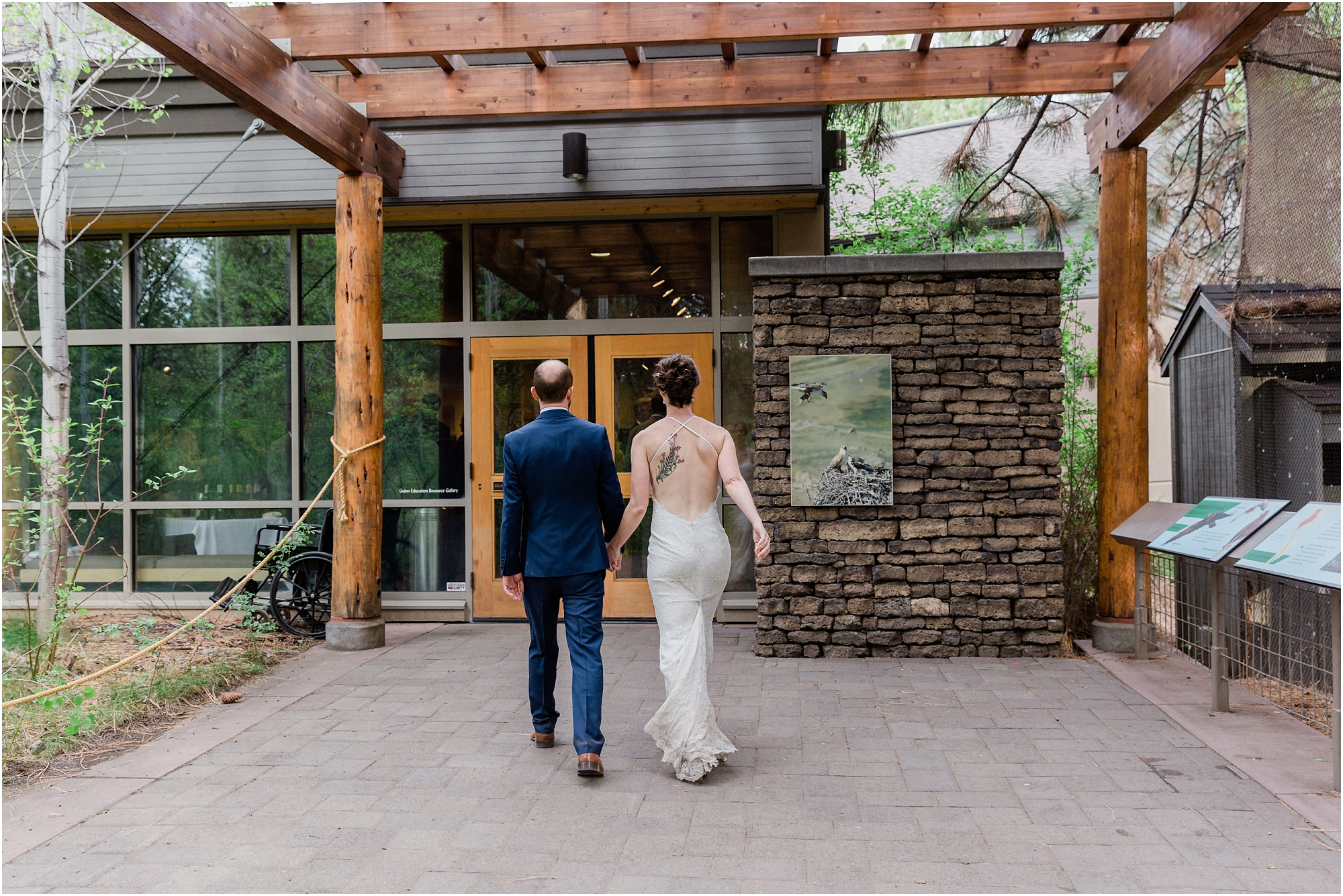 A couple walks into the Birds of Prey exhibit to join their guests for cocktail hour at their High Desert Museum homestead wedding in Bend, Oregon. | Erica Swantek Photography
