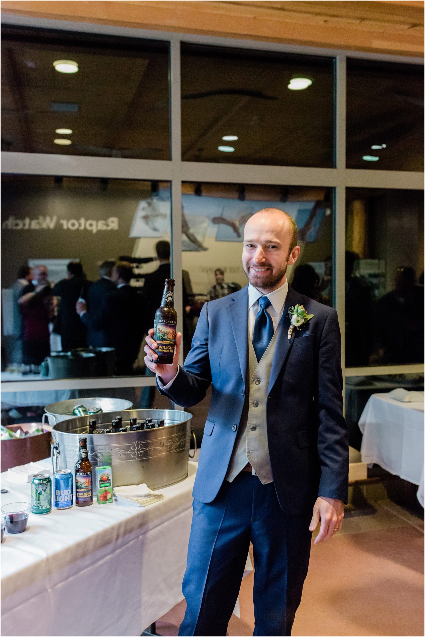 It's time for this dapper groom, dressed in a blue suit, to enjoy his Deschutes Brewery craft beer at his Bend, Oregon wedding. | Erica Swantek Photography
