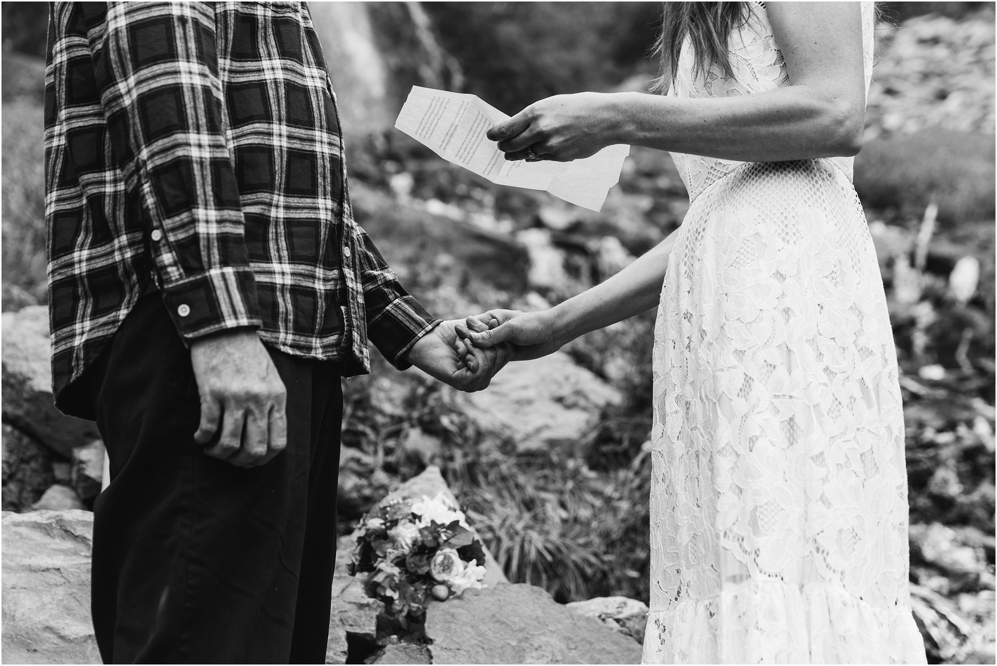 A gorgeous black and white image of a bride reading her vows as her husband holds her hand at their wedding in Crater Lake National Park in Oregon. | Erica Swantek Photography