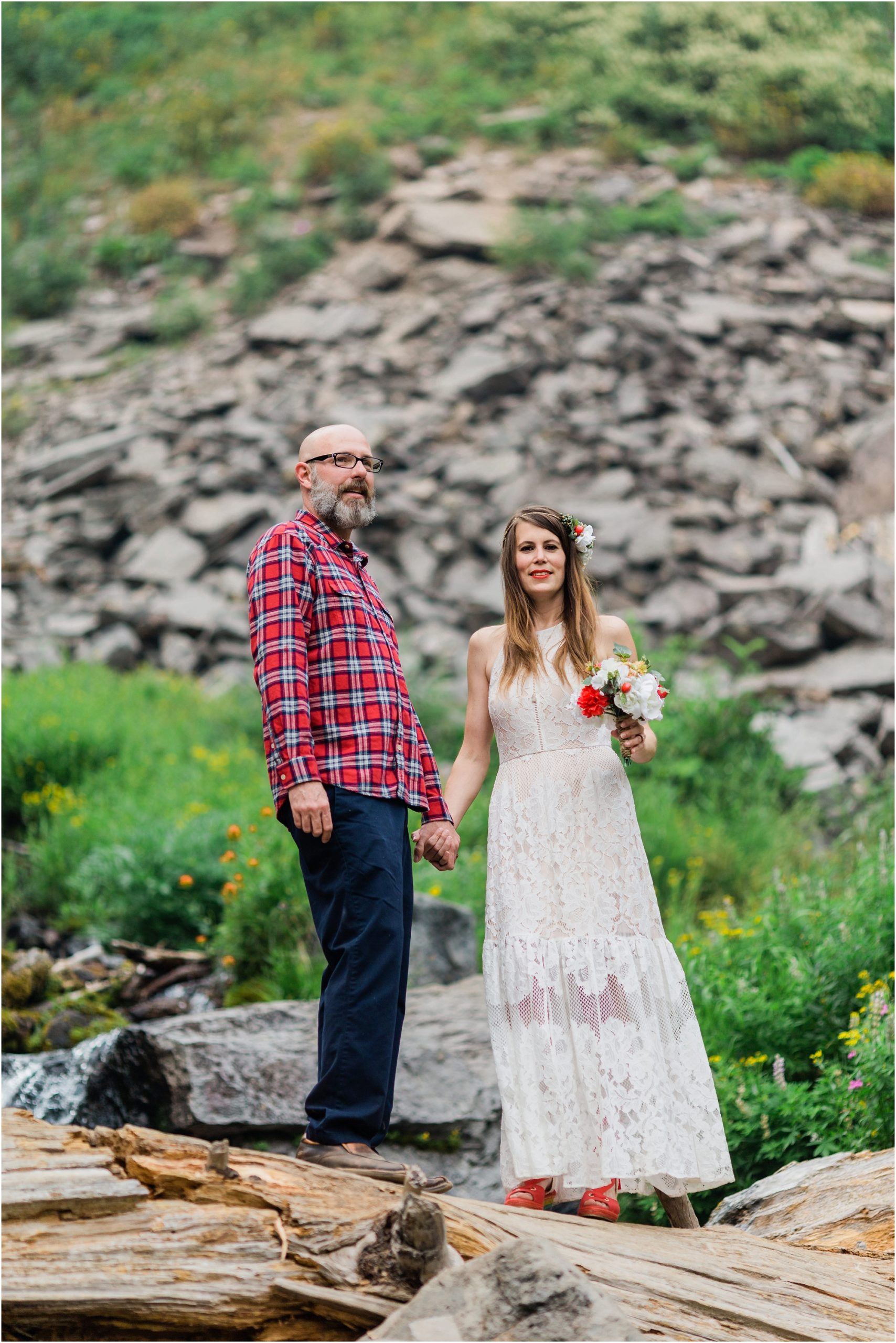 An indie elopement at Crater Lake National Park, the groom wearing red plaid and navy slacks, the bride in a gorgeous boho gown with flowers in her hair. | Erica Swantek Photography