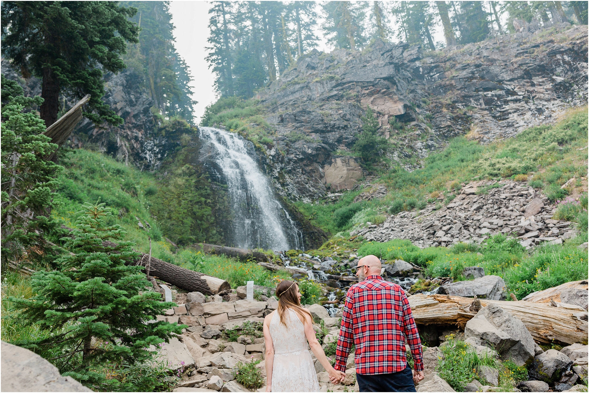 A newly married couple gazes off at the waterfall they just eloped under at Crater Lake National Park in Oregon. | Erica Swantek Photography