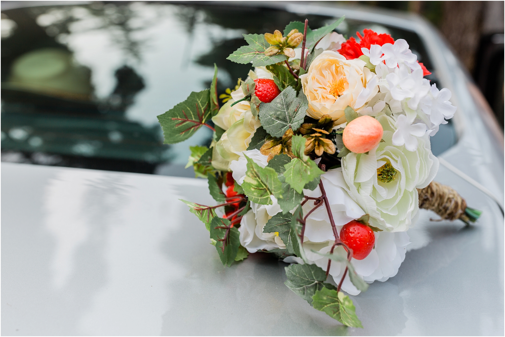 A beautiful DIY bouquet made from fake flowers, strawberries and greenery for an elopement at Crater Lake National Park in Oregon. | Erica Swantek Photography