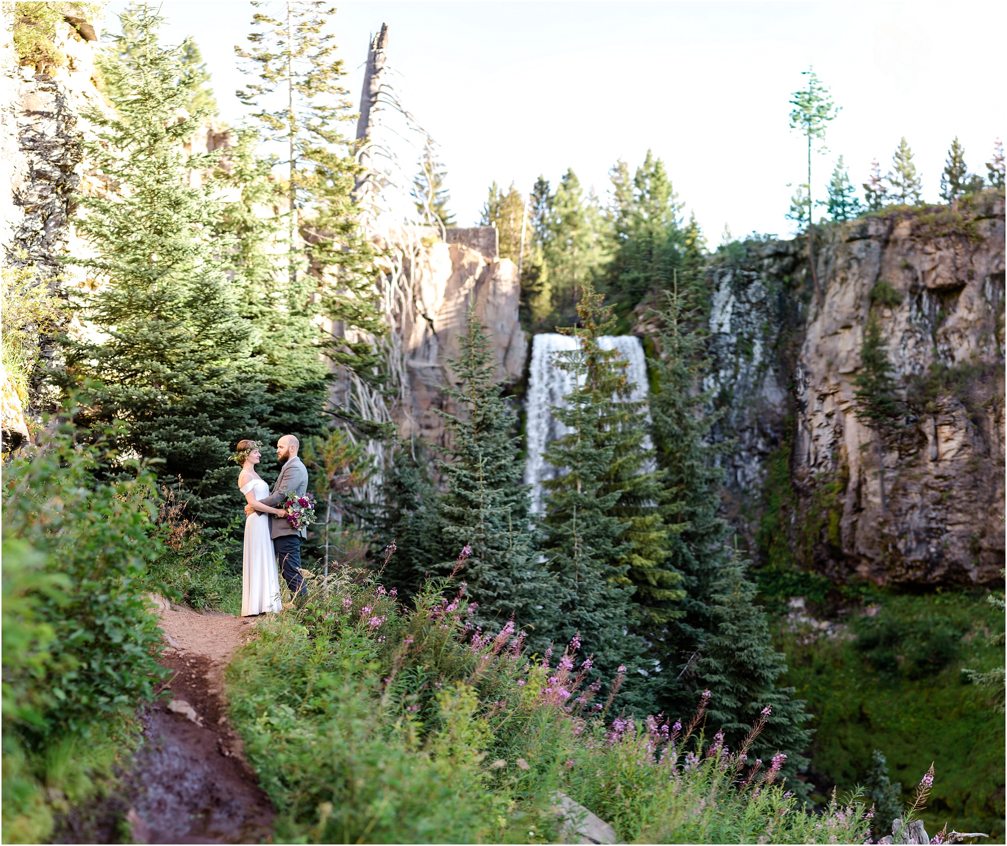 A wide sweeping panoroma of Tumalo Falls with a couple dressed in their wedding clothes after their Bend Oregon elopement. | Erica Swantek Photography