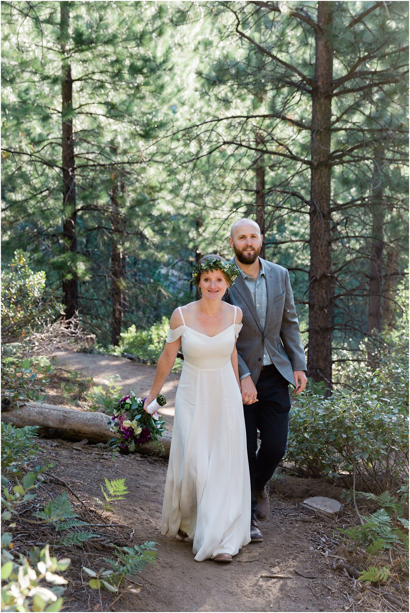 A beautiful bride wearing a white Reformation flutter sleeve dress leads her groom, dressed in navy, down the trail for portraits of their Tumalo Falls elopement in Bend, Oregon. | Erica Swantek Photography