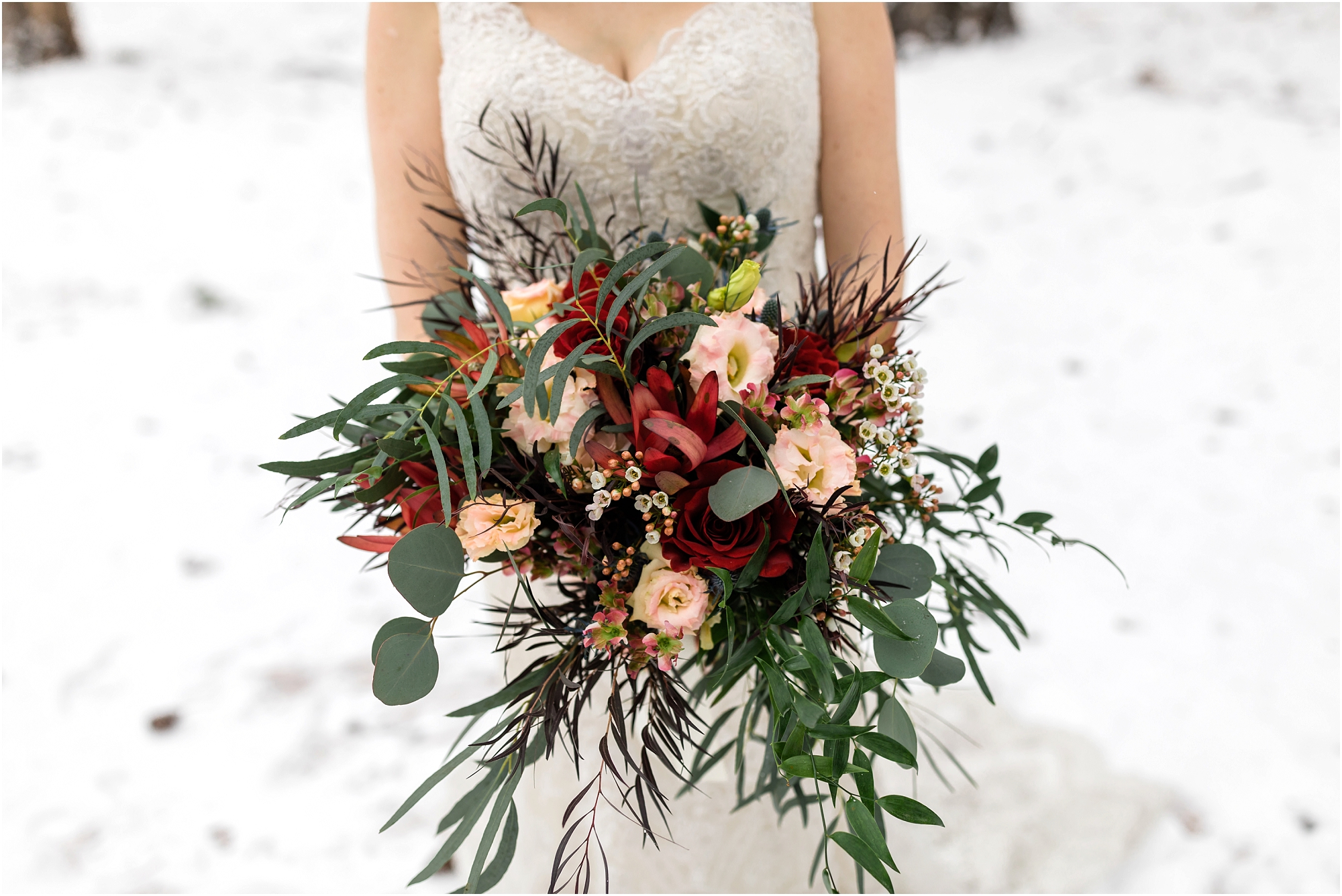 A gorgeous bouquet or red and pink roses and greenery from Woodland Floral in Sisters for this gorgeous Central Oregon winter elopement bride. | Erica Swantek Photography