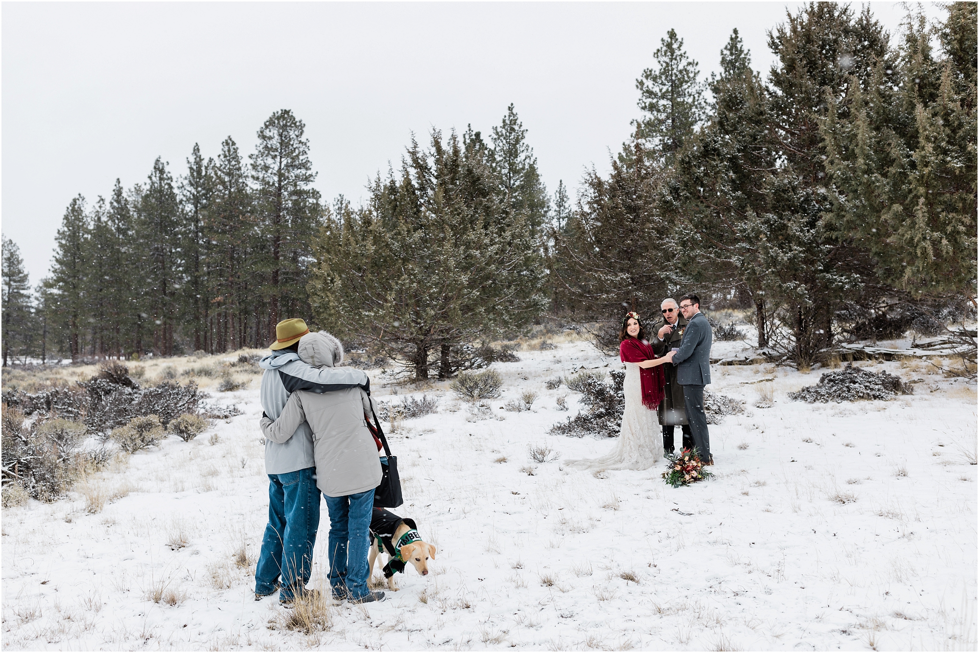 The bride's parents embrace as they watch their daughter's intimate Central Oregon winter elopement near Five Pine Lodge in Sisters, Oregon. | Erica Swantek Photography