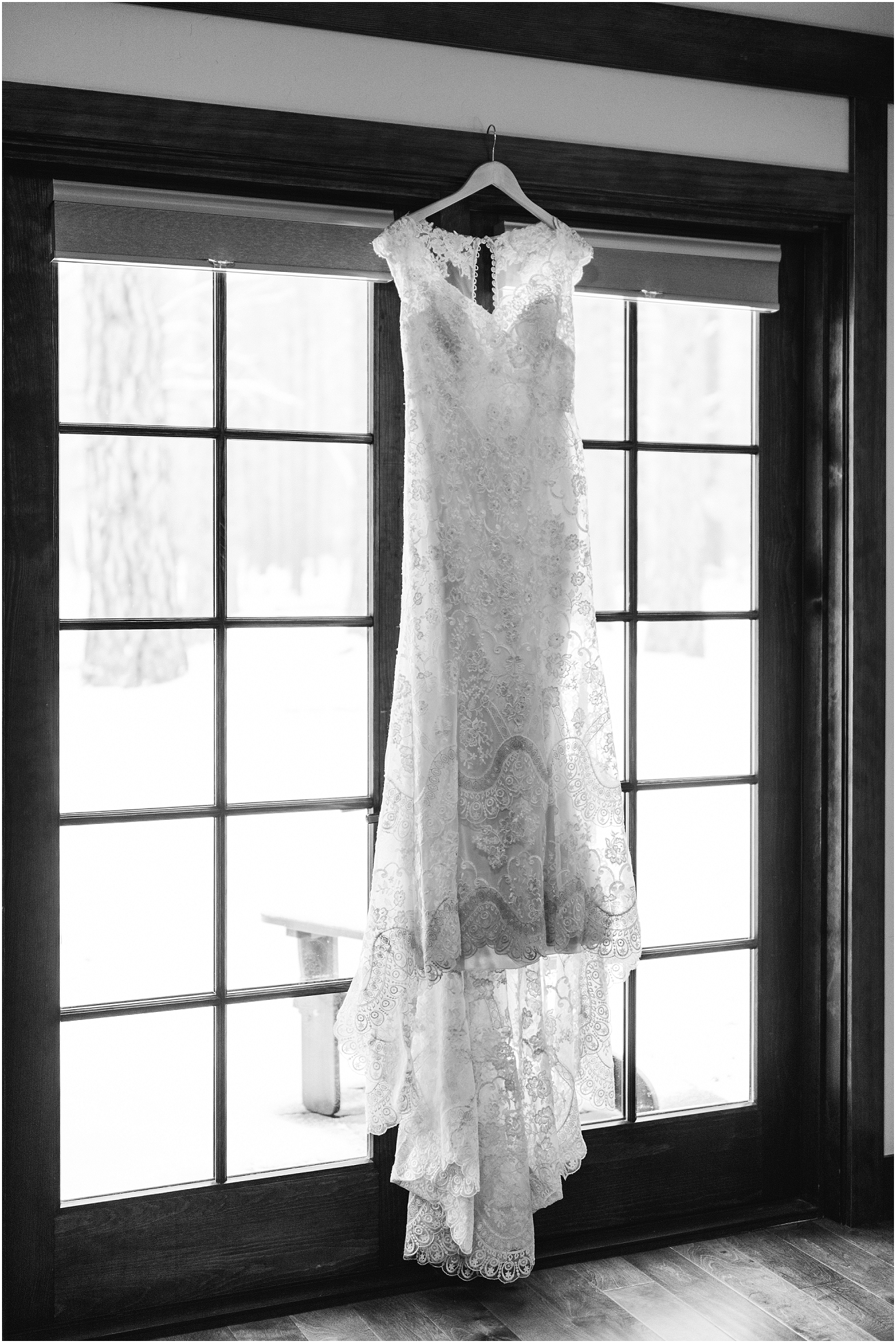 A gorgeous wedding gown hangs in the window of the bridal cabin at Five Pine Lodge in Sisters, OR. | Erica Swantek Photography