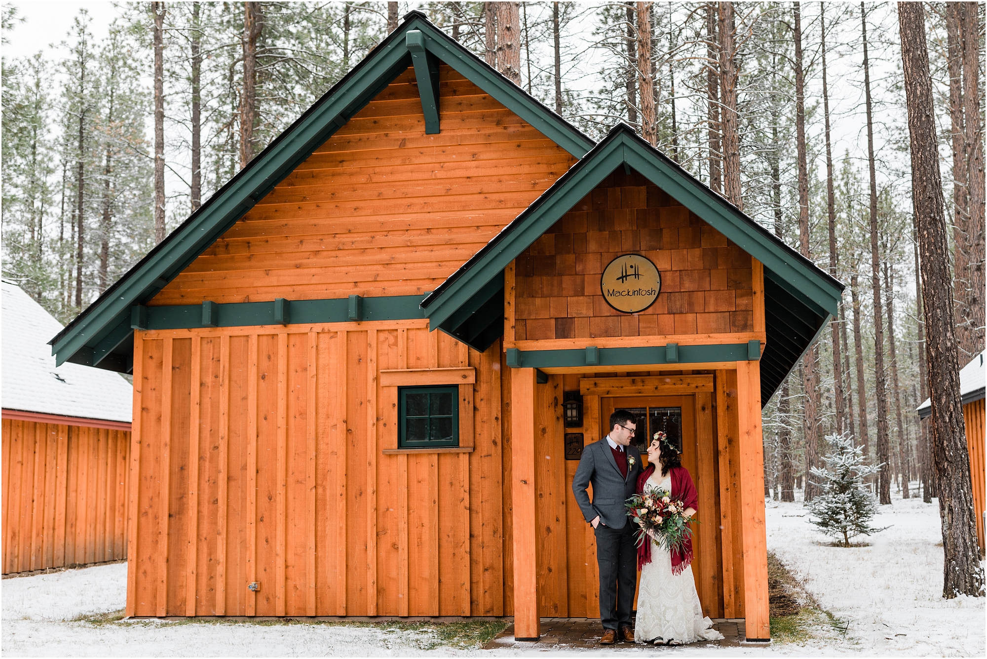 A couple stands in front of their cabin at Five Pine Lodge in Sisters, OR wearing their wedding attire as a blanket of snow covers the ground. | Erica Swantek Photography
