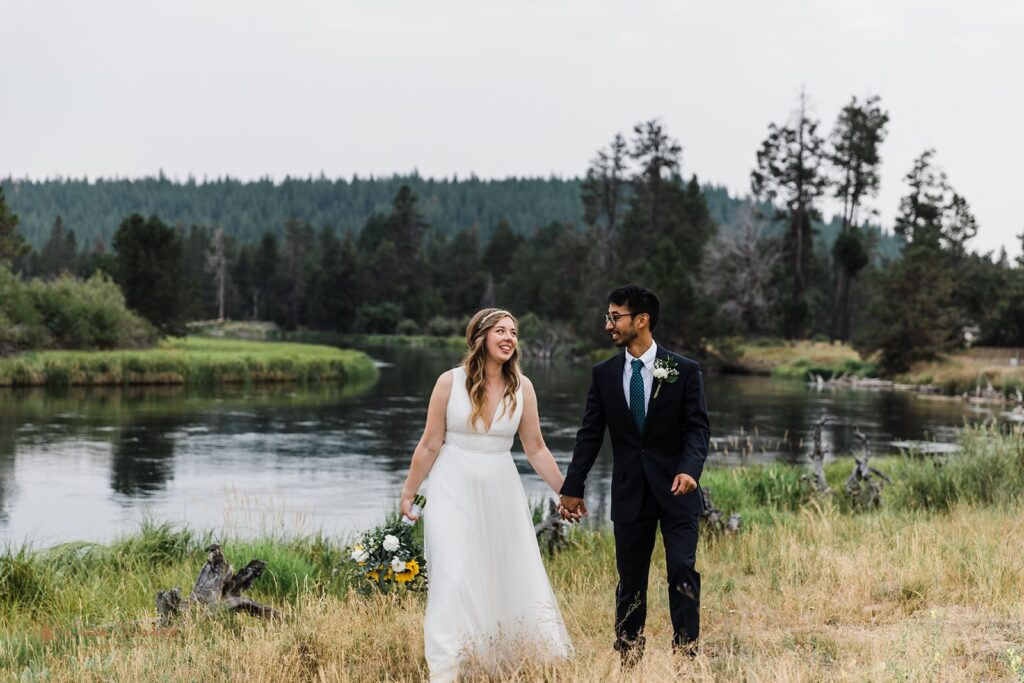 bride and groom walking hand in hand during their elopement in sunriver, oregon