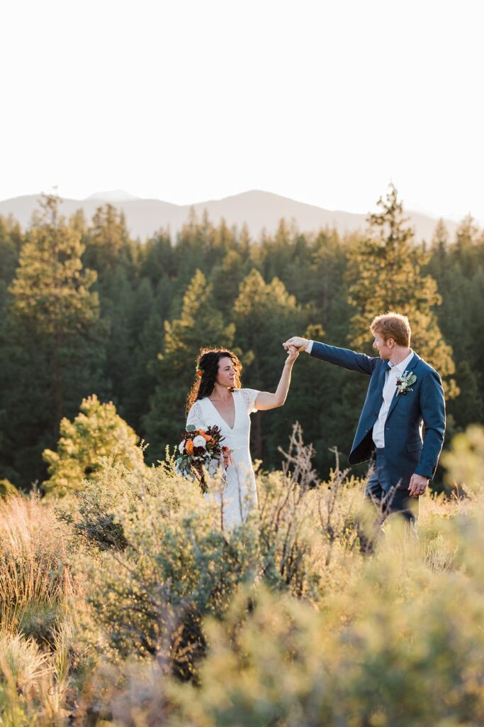 bride and groom in a lush sunlit field during their bend oregon elopement day
