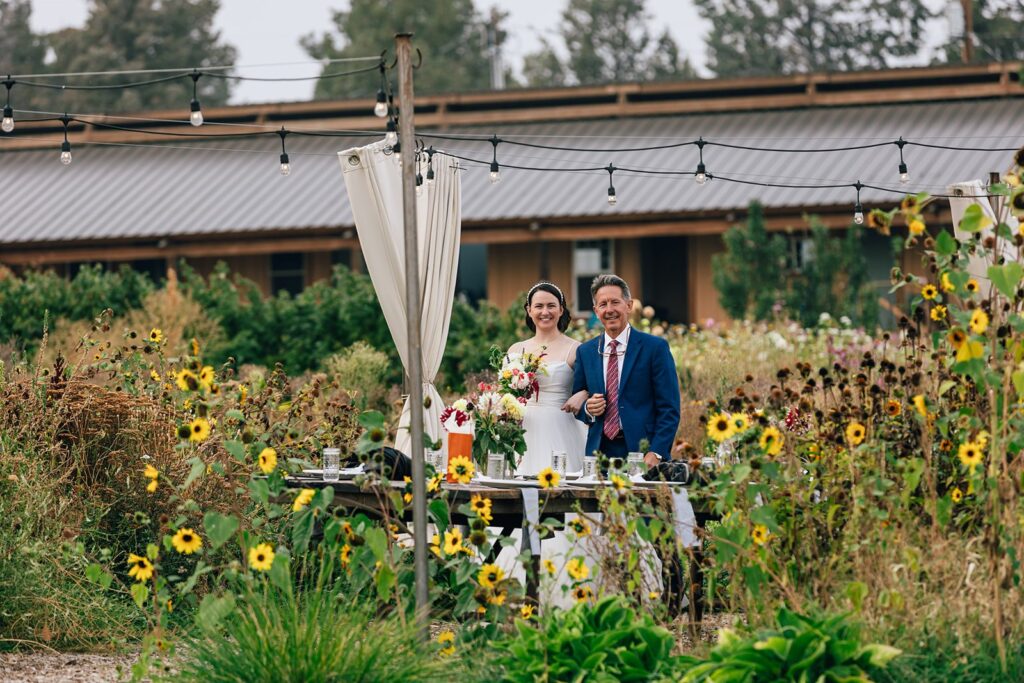 happy bride and dad walking together during the rainshadow organics farm wedding day