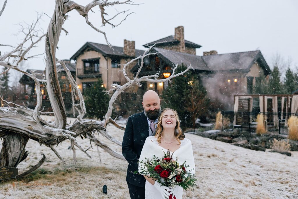 excited bride and groom hugging outside during their snowy elopement in bend