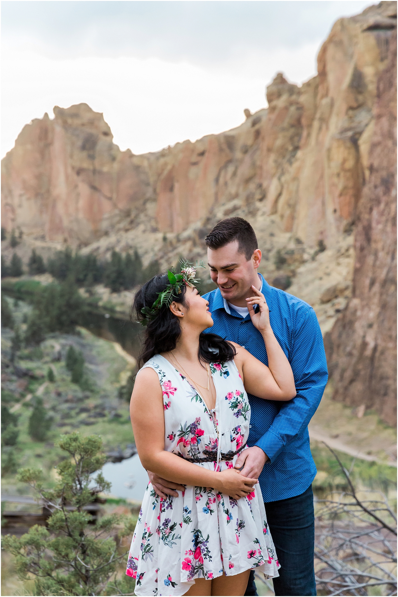 A bride in a floral dress and crown looks adoringly into her groom's eyes at their Smith Rock elopement near Bend, Oregon. | Erica Swantek Photography