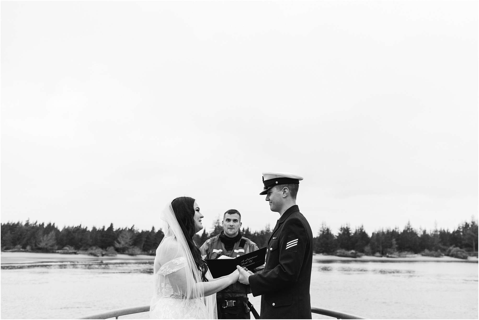 An Oregon Coast Guard elopement, officiated on the deck of the ship in Winchester Bay, Oregon with a groom wearing his navy Coast Guard uniform and a bride wearing a blush pink gown and white veil. | Erica Swantek Photography