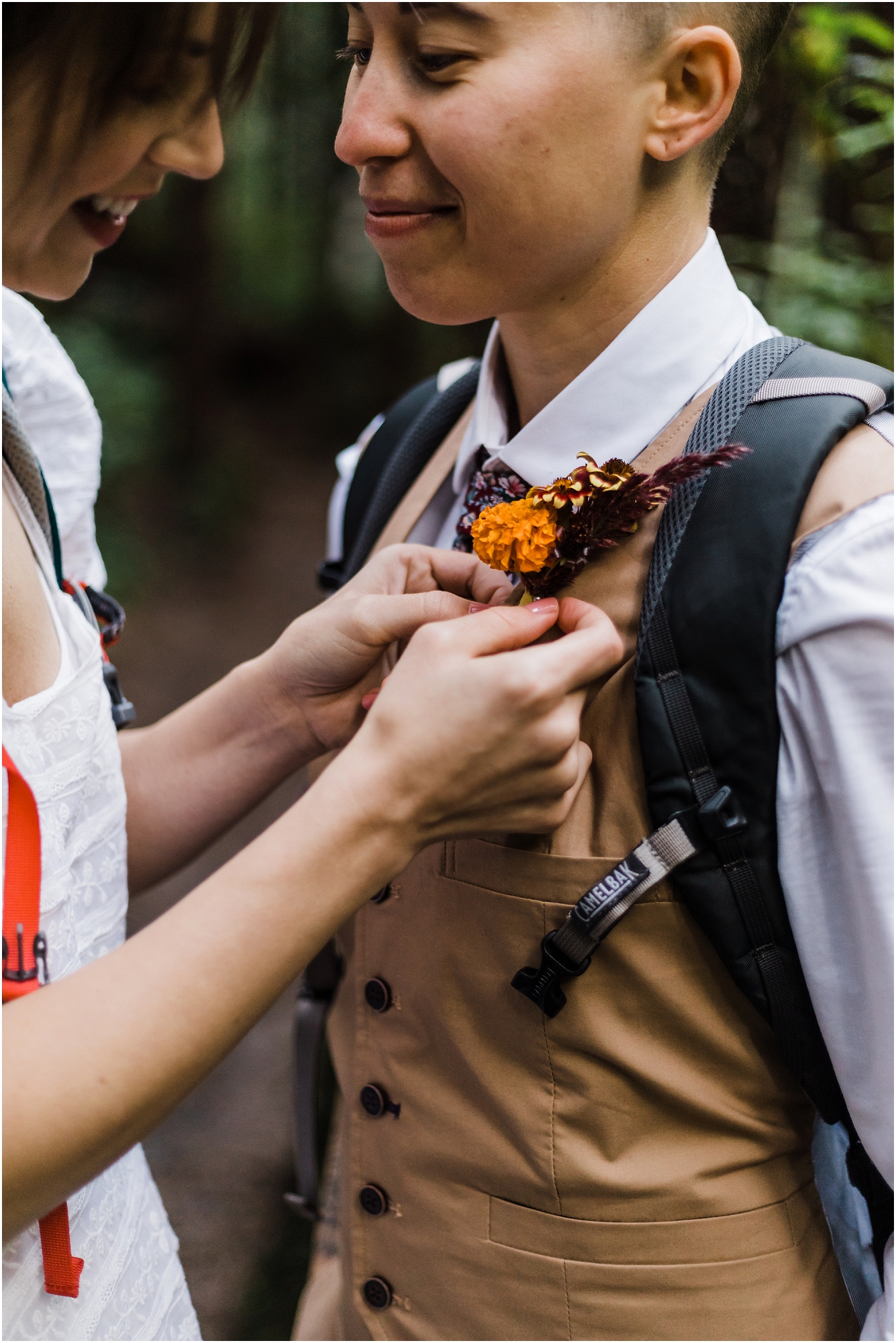 Pinning the orange marigold boutonnière on the vest of the groom before his PNW hiking adventure elopement. | Erica Swantek Photography 