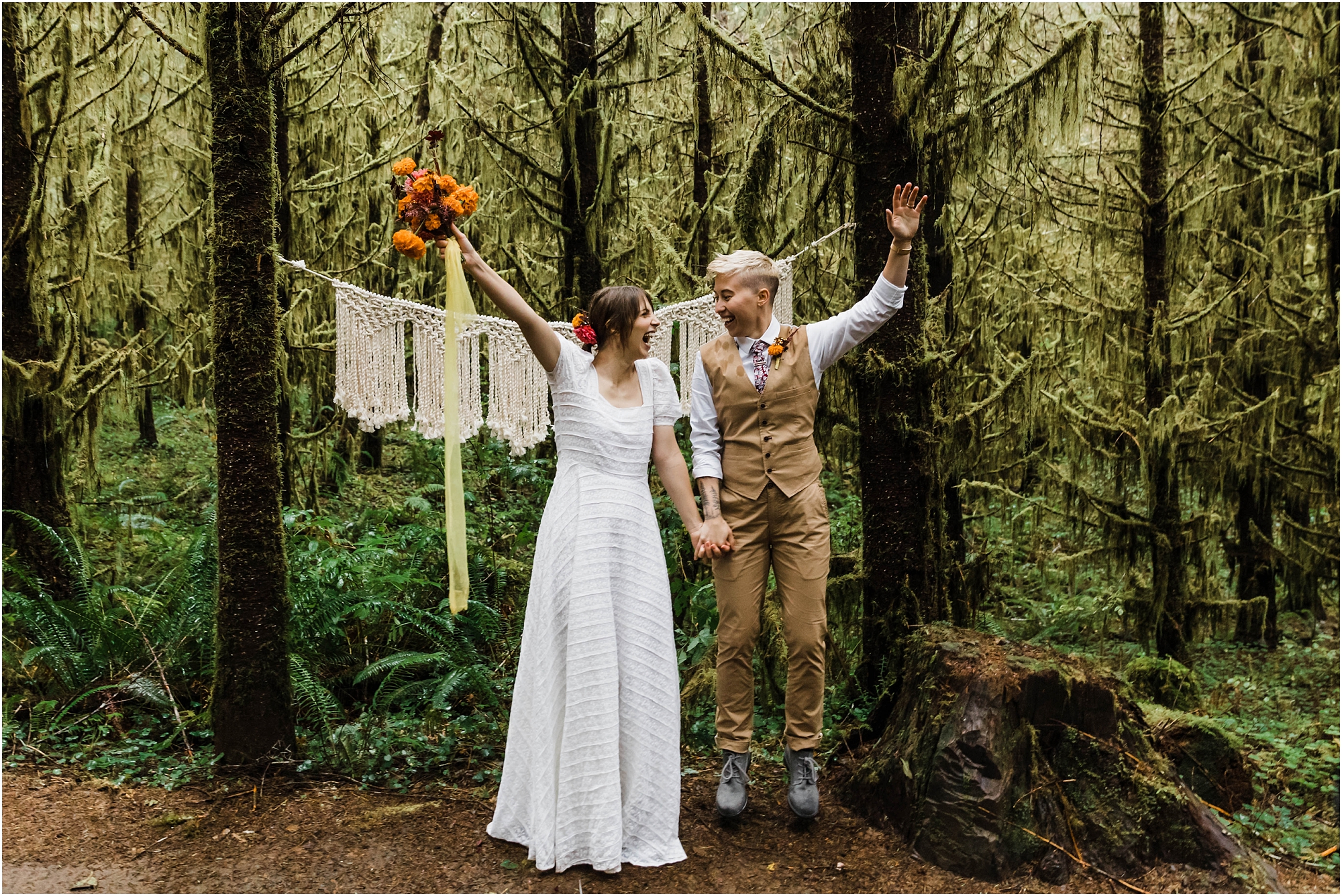 A LGBTQ+ couple celebrates their union by raising their hands in the air and jumping after their gorgeous PNW hiking adventure elopement ceremony in Oregon. | Erica Swantek Photography