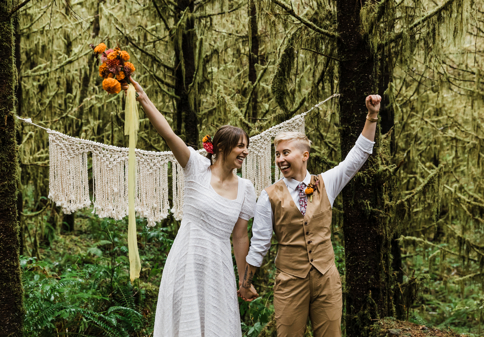 A LGBTQ+ couple celebrates their union by raising their hands in the air and jumping after their gorgeous PNW hiking adventure elopement ceremony in Oregon. | Erica Swantek Photography
