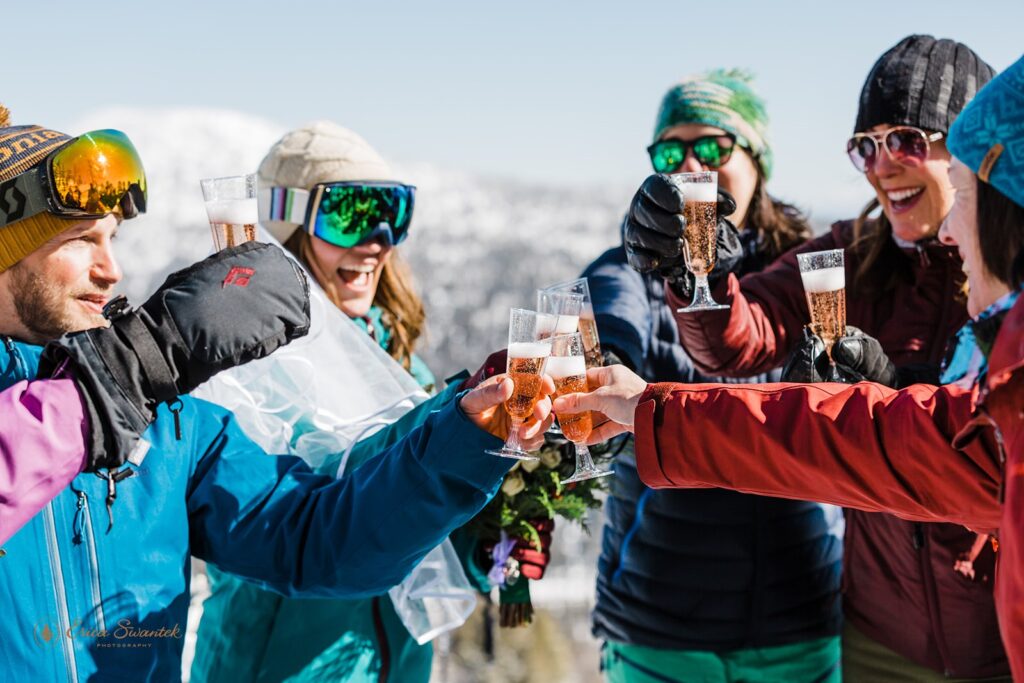 elopement couple toasting champagne on the mountain with their friends