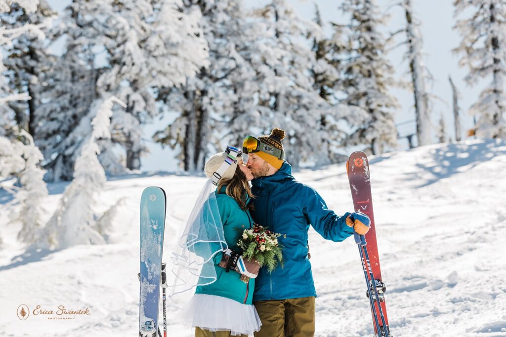 bride and groom kissing in their ski gear during their ski elopement 